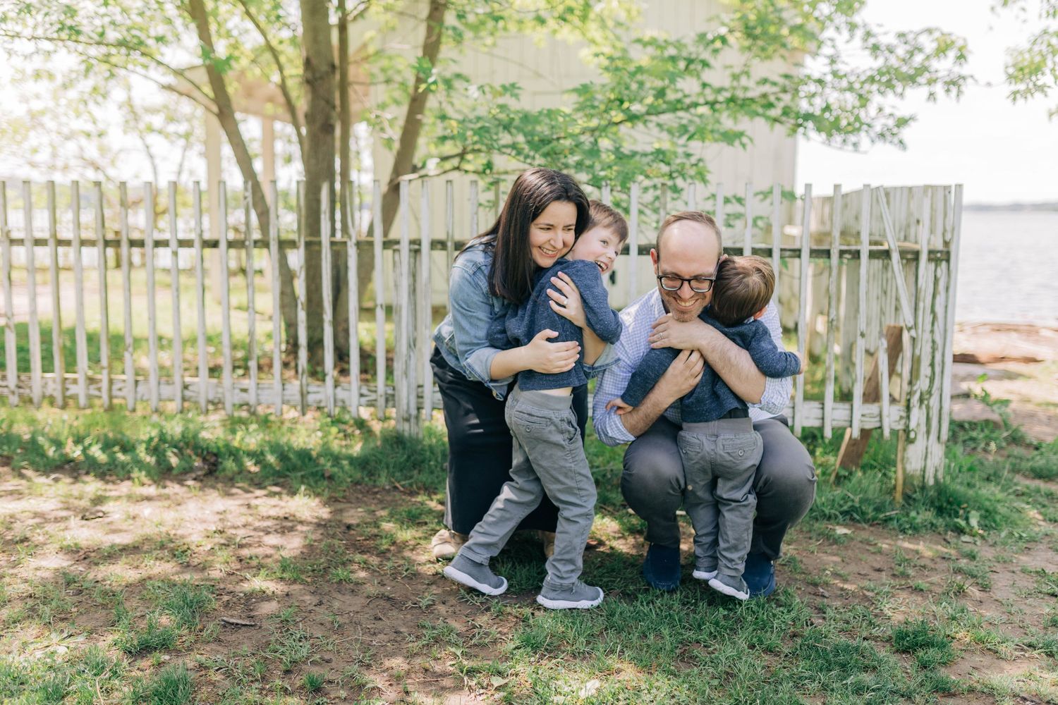 Candid family moments captured in a backyard setting with wooden fence and greenery.