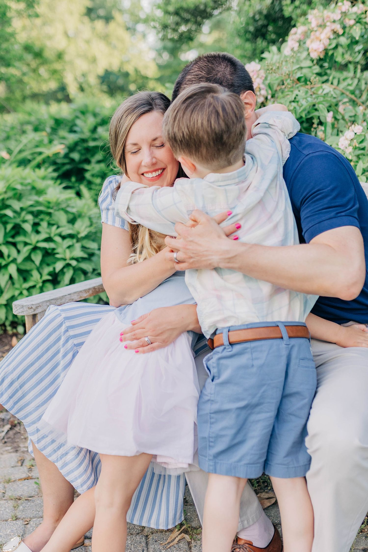 Family photo session showing genuine moments of affection in a blooming garden.