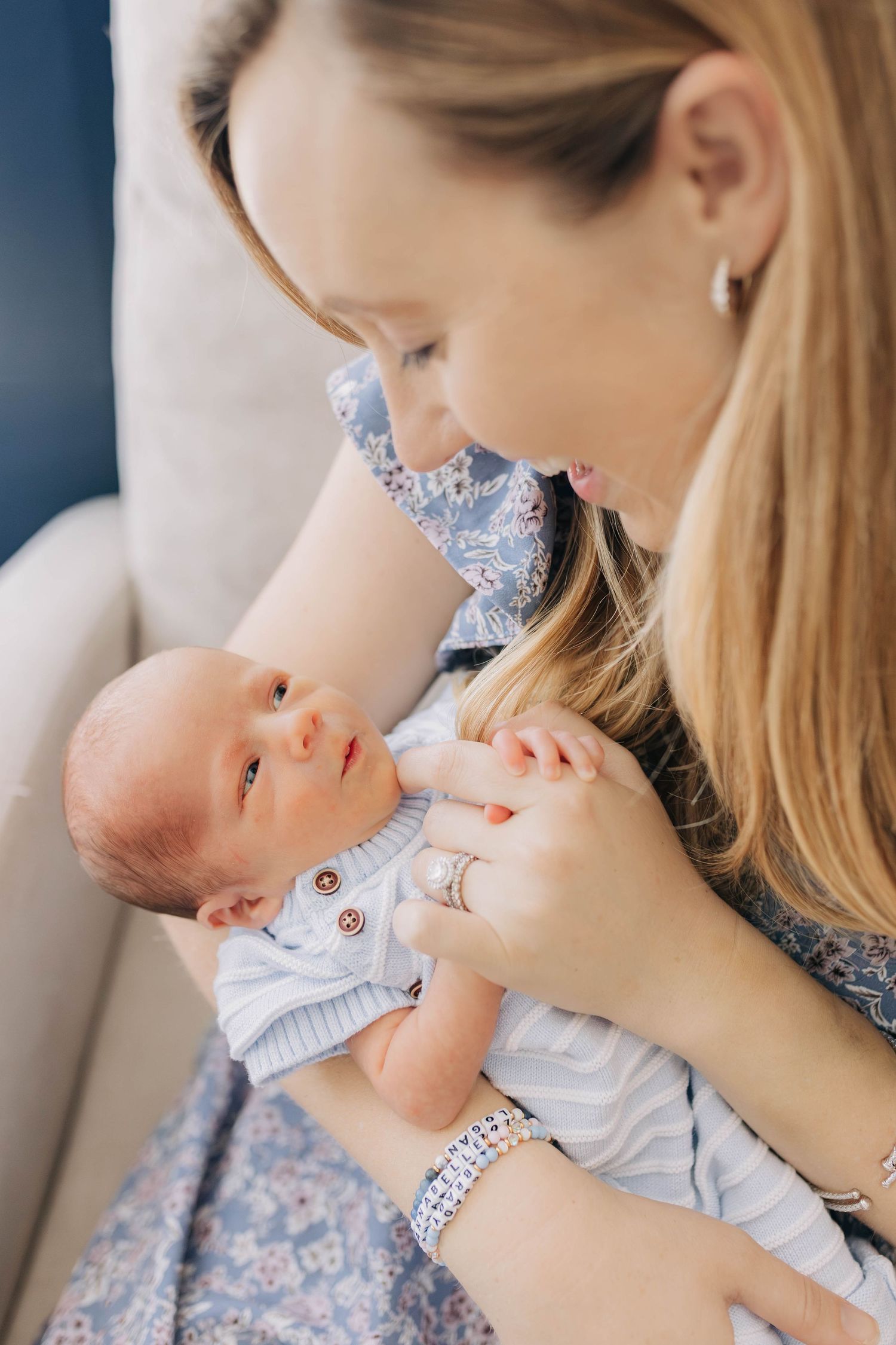 A young mother tenderly holds her newborn baby, gazing lovingly at the infant in her arms.