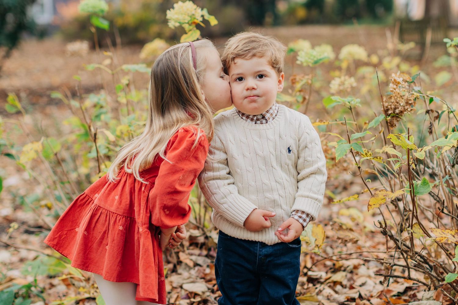 A sweet outdoor family photo session amidst autumn leaves and natural scenery.