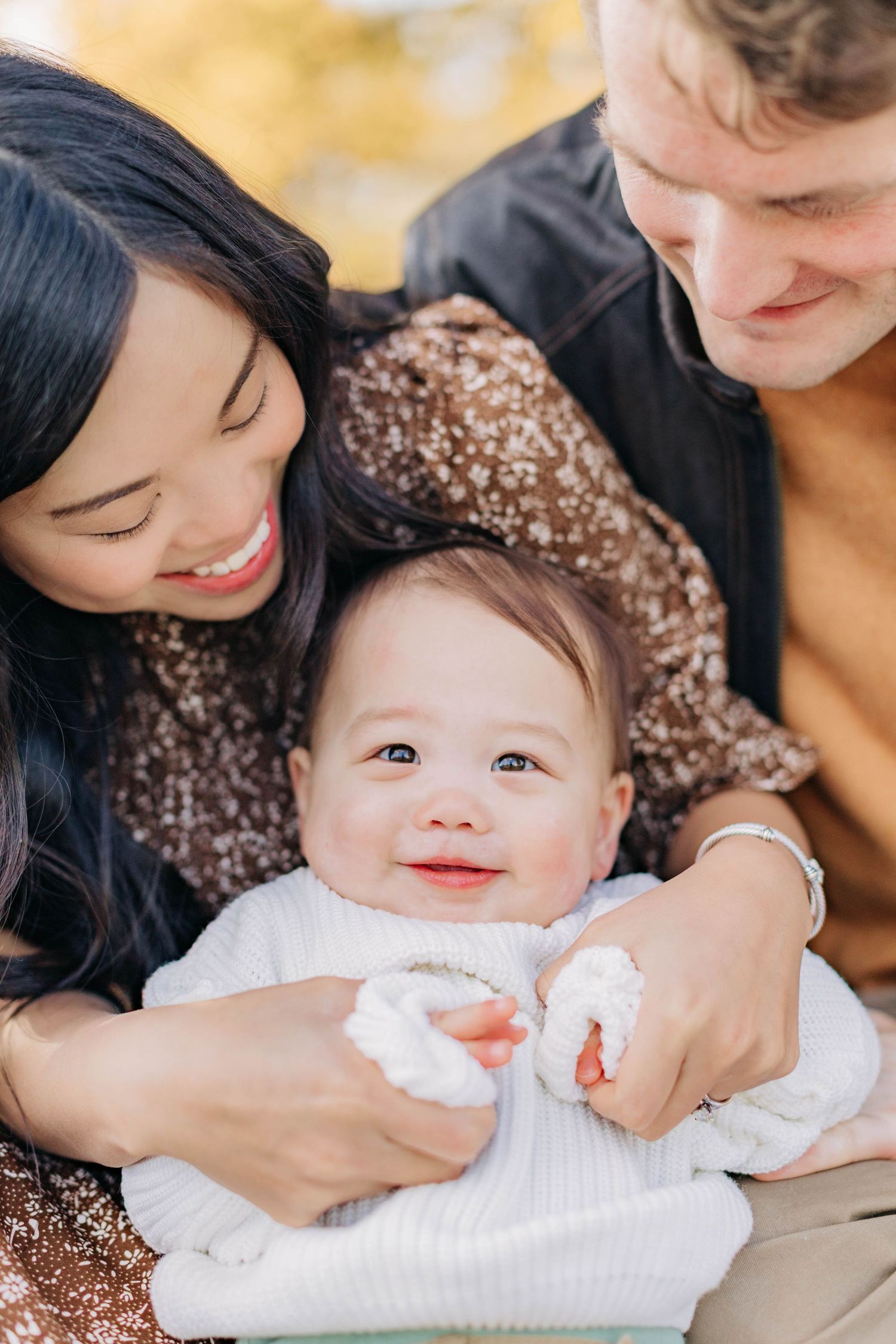 Intimate family portrait session capturing tender moments with baby outdoors.