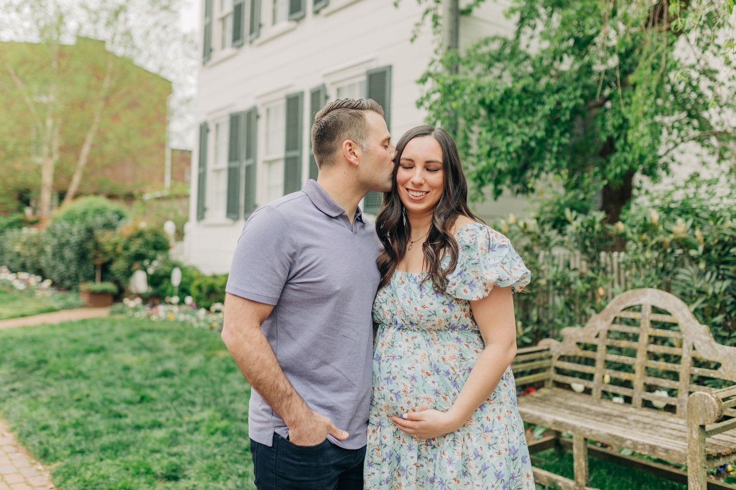 A couple shares tender moments together in a garden setting during a photo session.