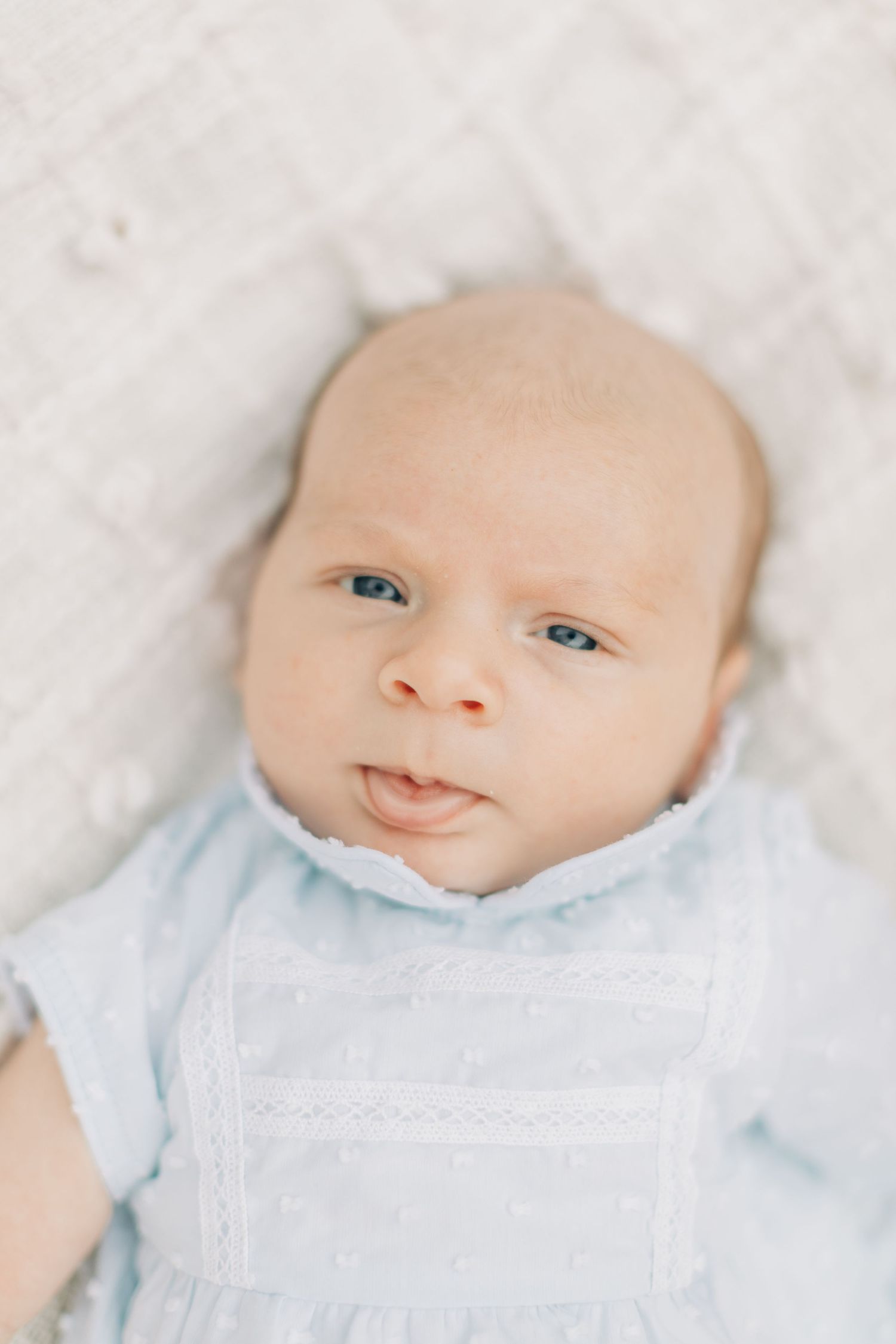 Baby wearing light blue outfit against white background.