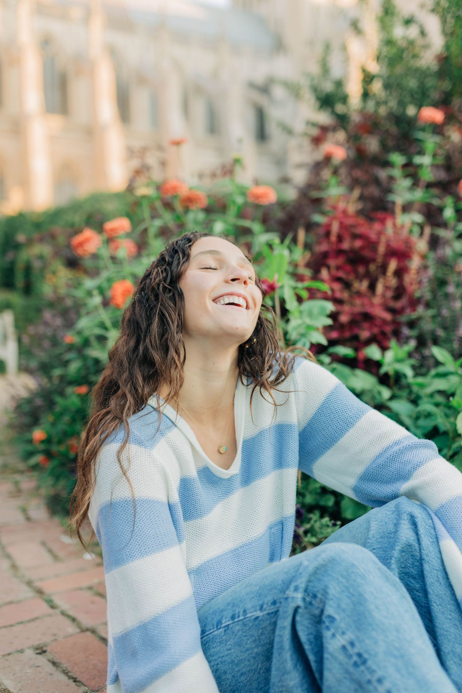 A joyful moment captured in a garden setting wearing casual blue and white attire.
