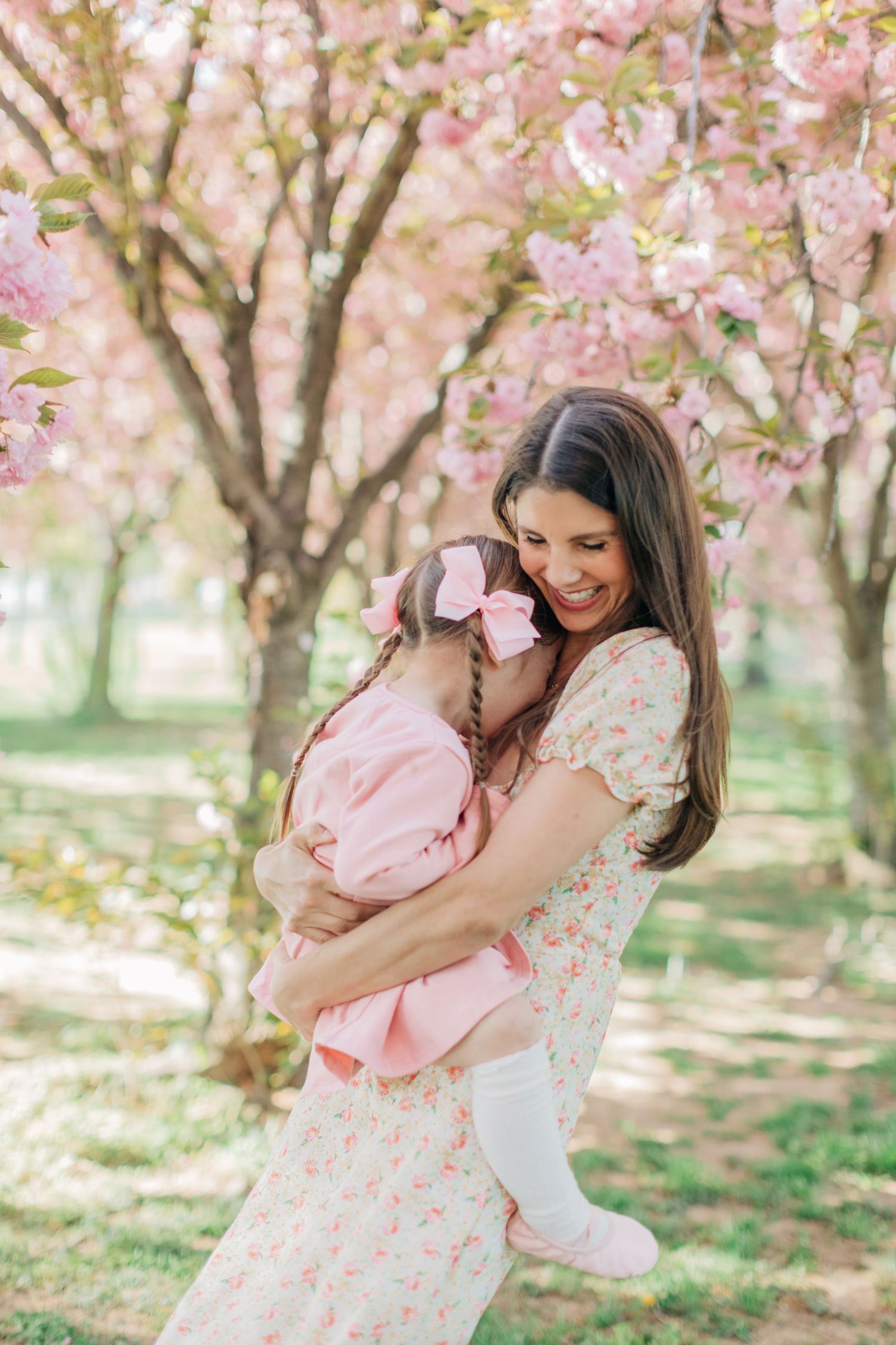 Loving embrace captured under blooming cherry trees in a spring garden.