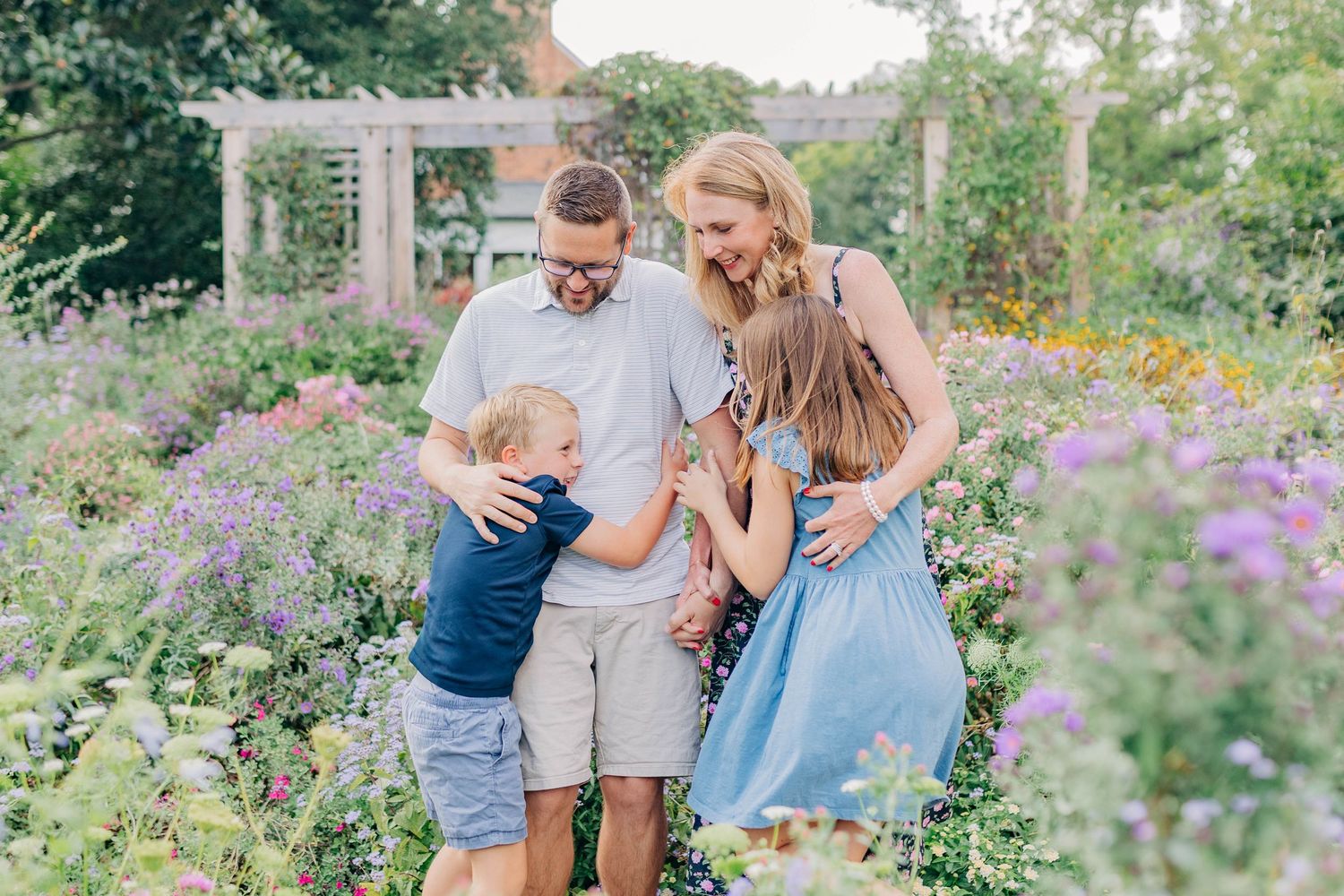 A family shares a tender moment together in a blooming flower garden.