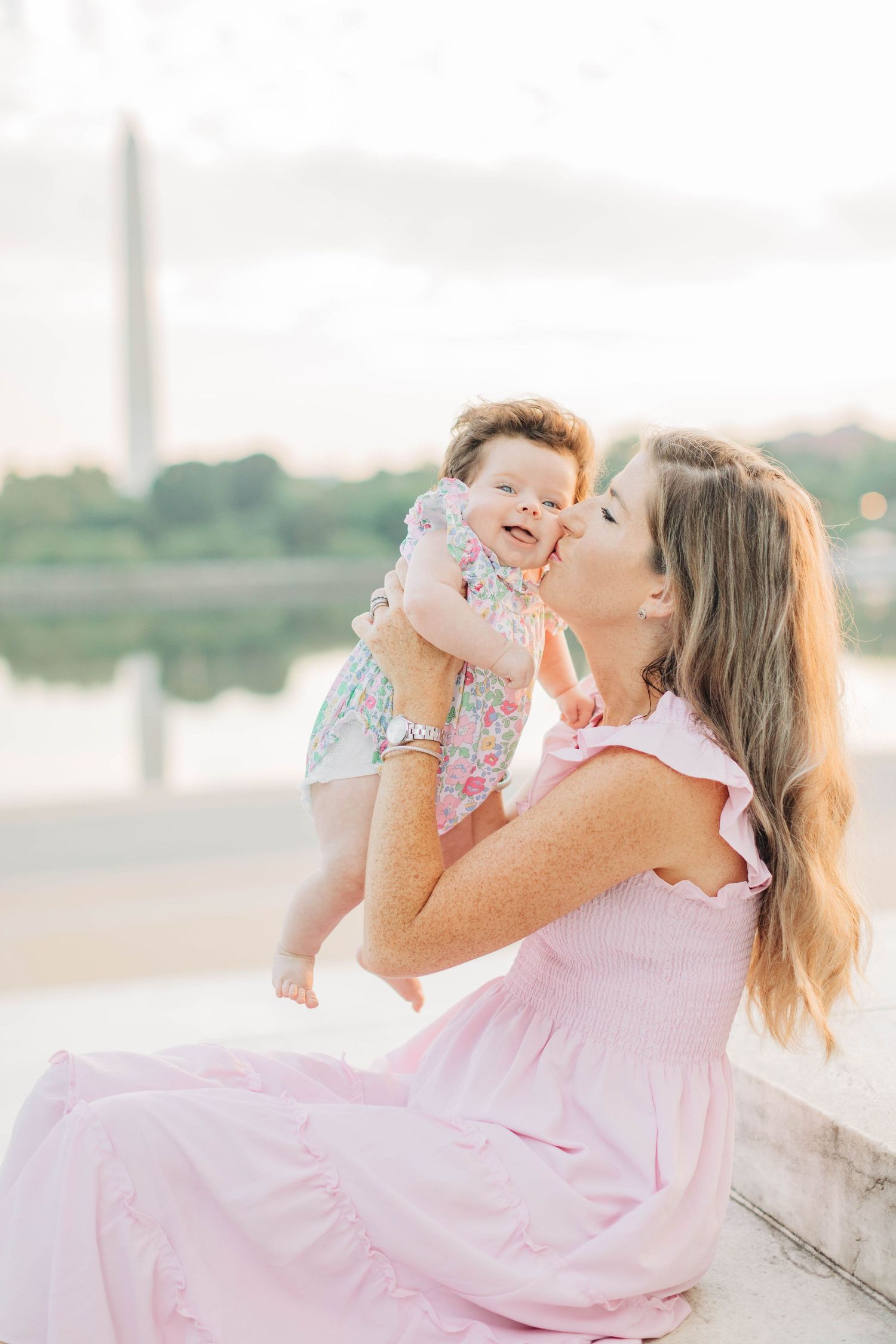 Joyful parent-child moment shared on stone steps during sunset photoshoot.