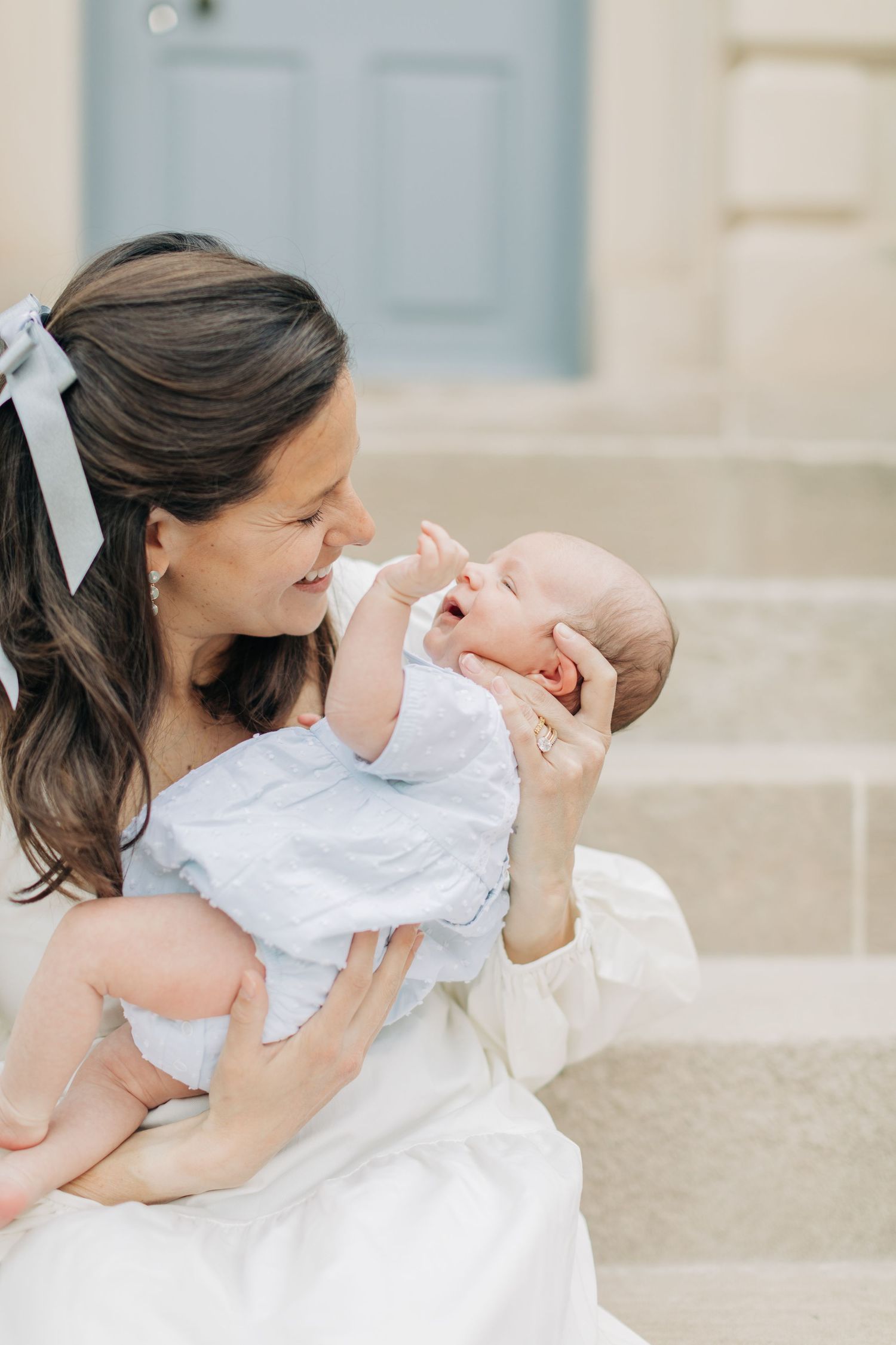 Mother and infant share tender moment on stone steps.