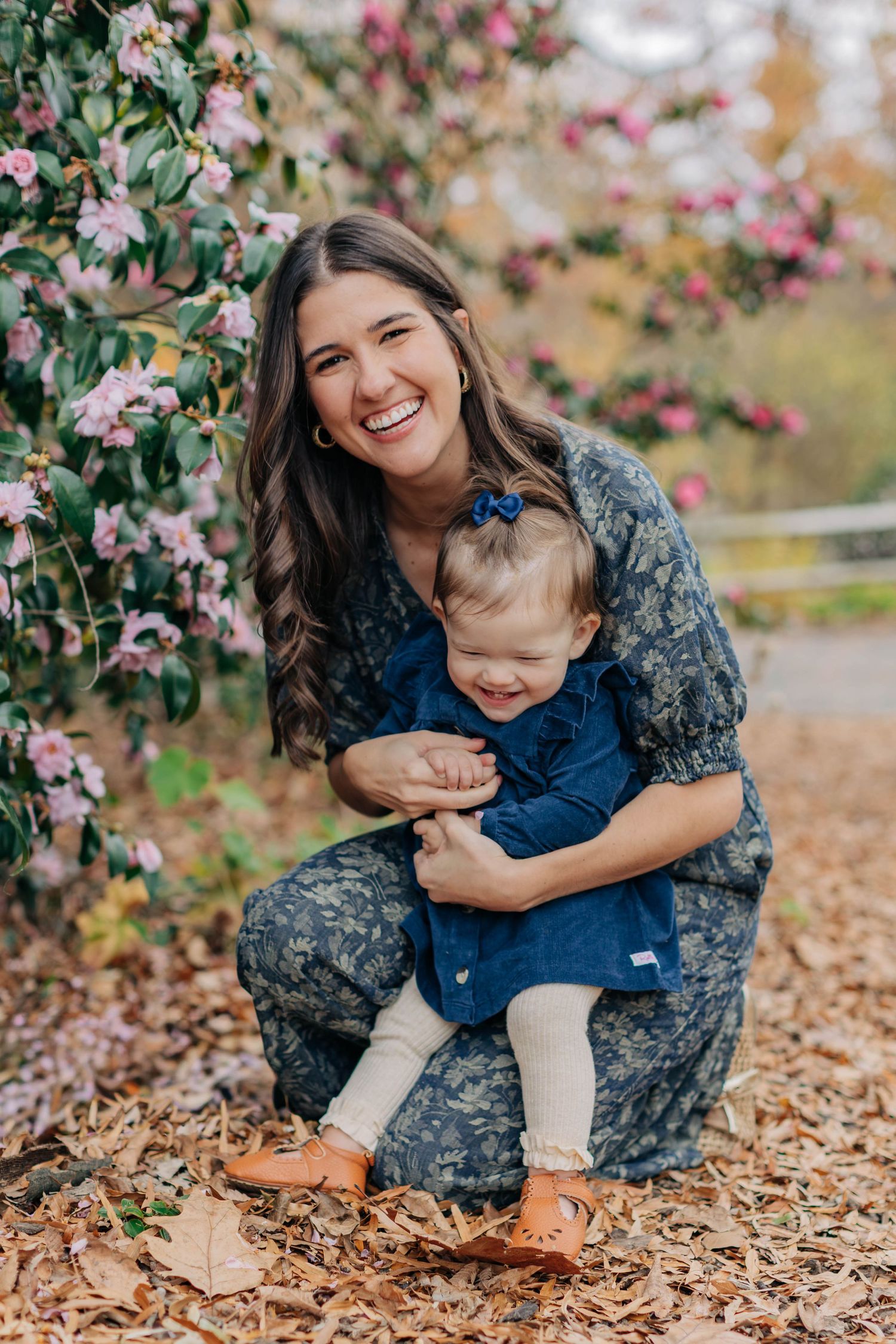 Military parent in camouflage uniform sharing playful moments with child among fall leaves.