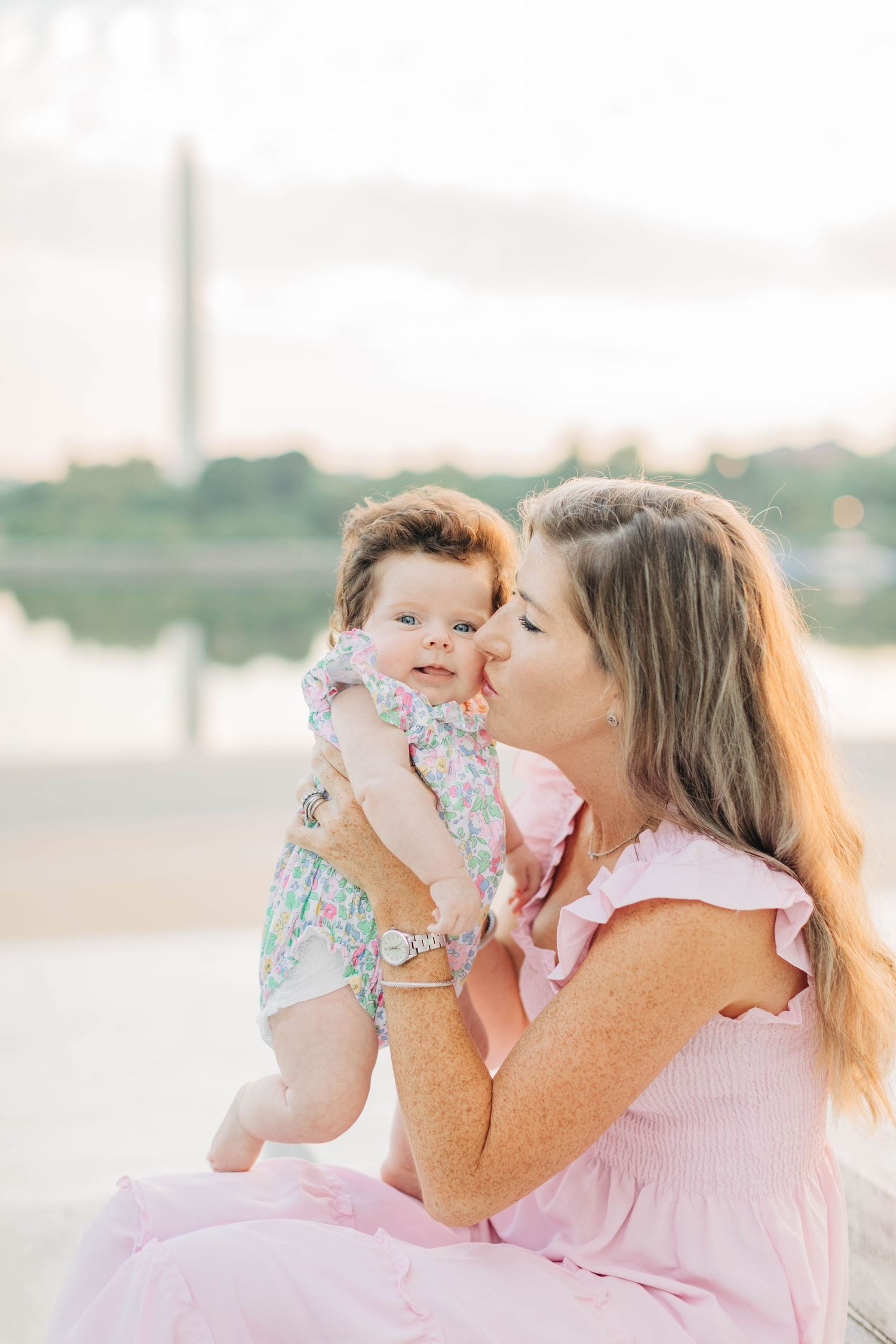 Sweet interaction between parent and baby against the backdrop of the Washington Monument.