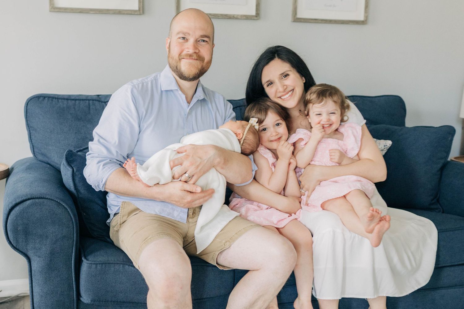 Family lifestyle photos showing intimate moments on a blue couch with white decor.