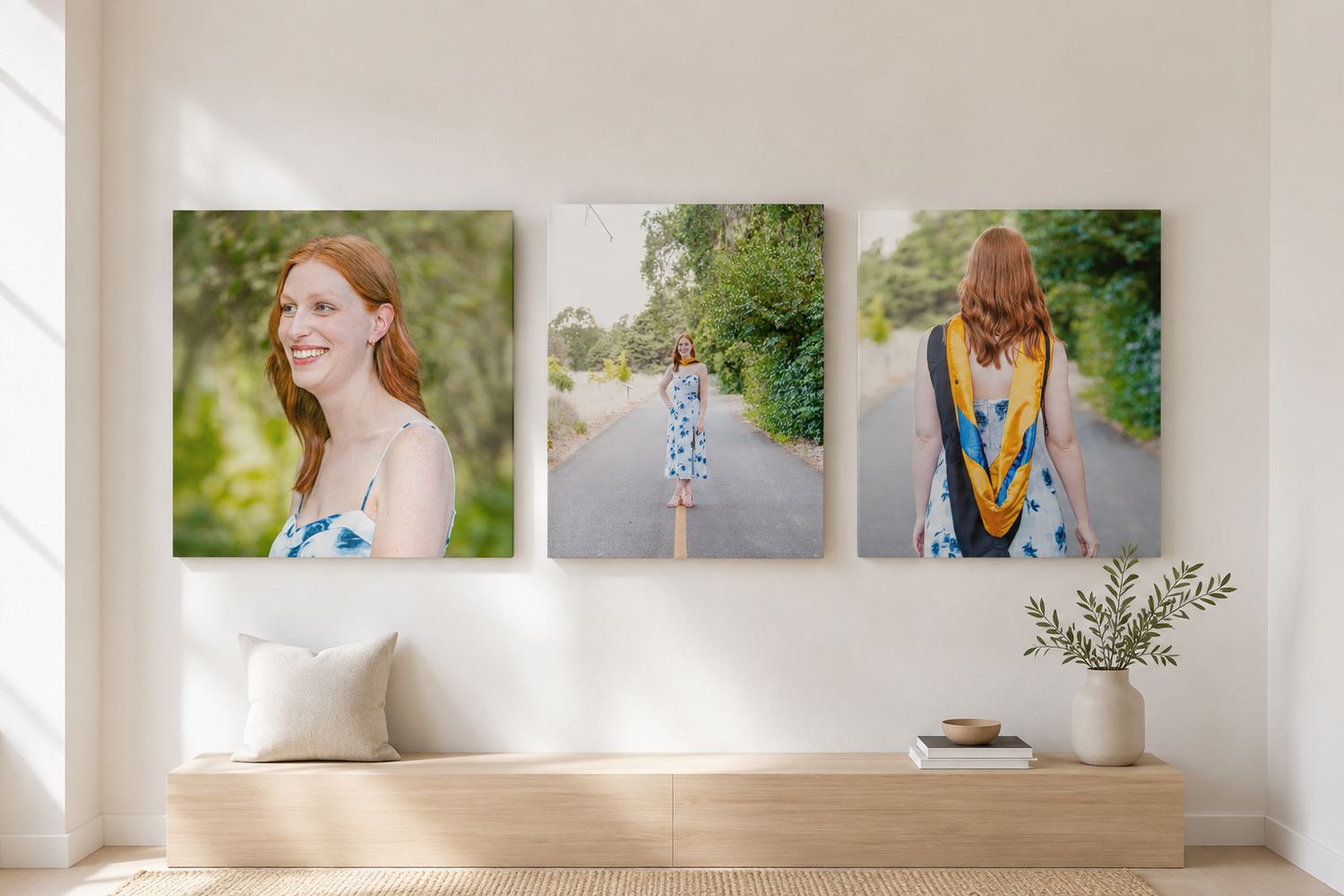 Three canvas wall prints of a redhead woman in a blue floral dress displayed above a wooden bench in a bright room.