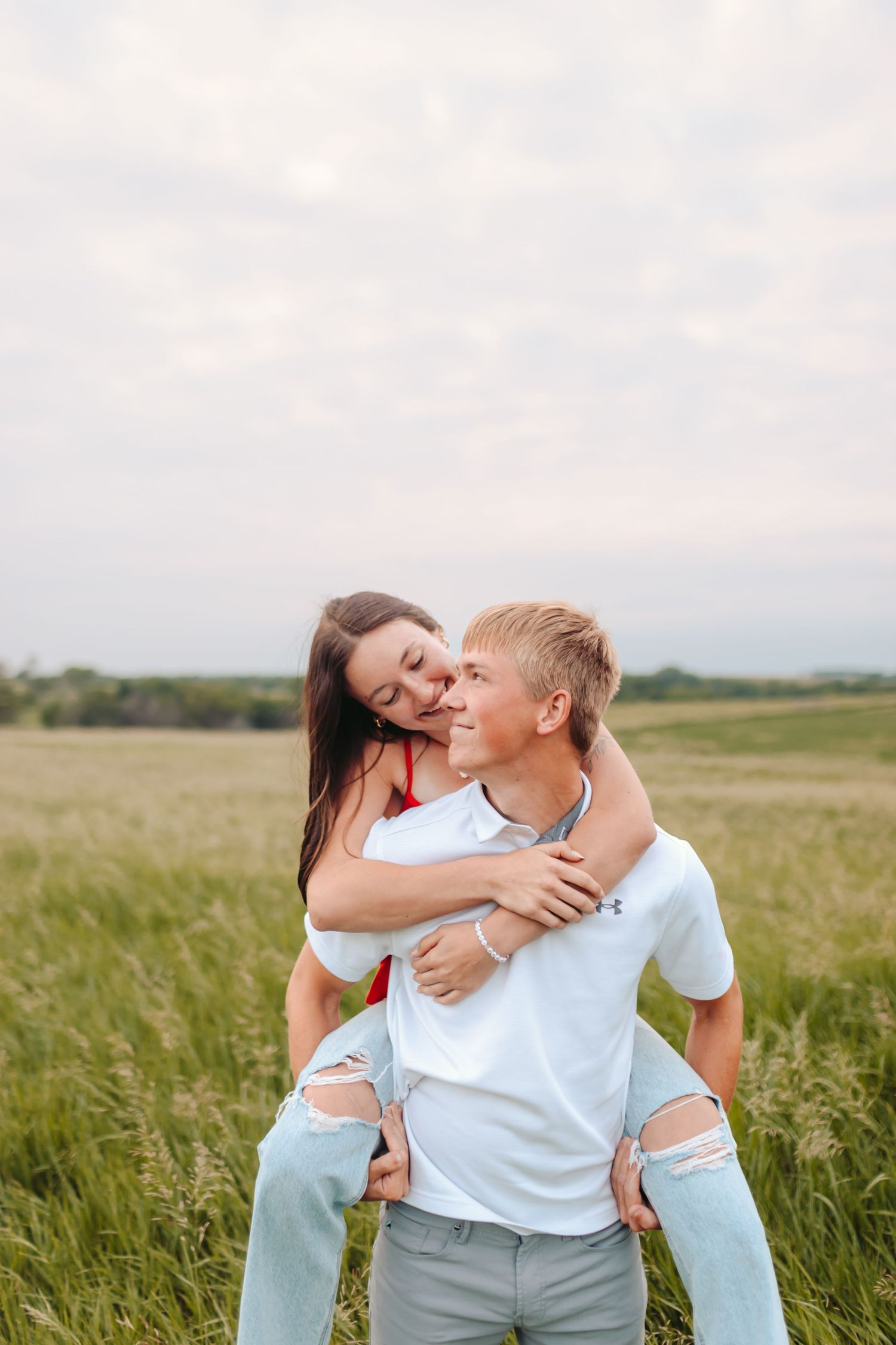 Couple playing in a field at sunset.