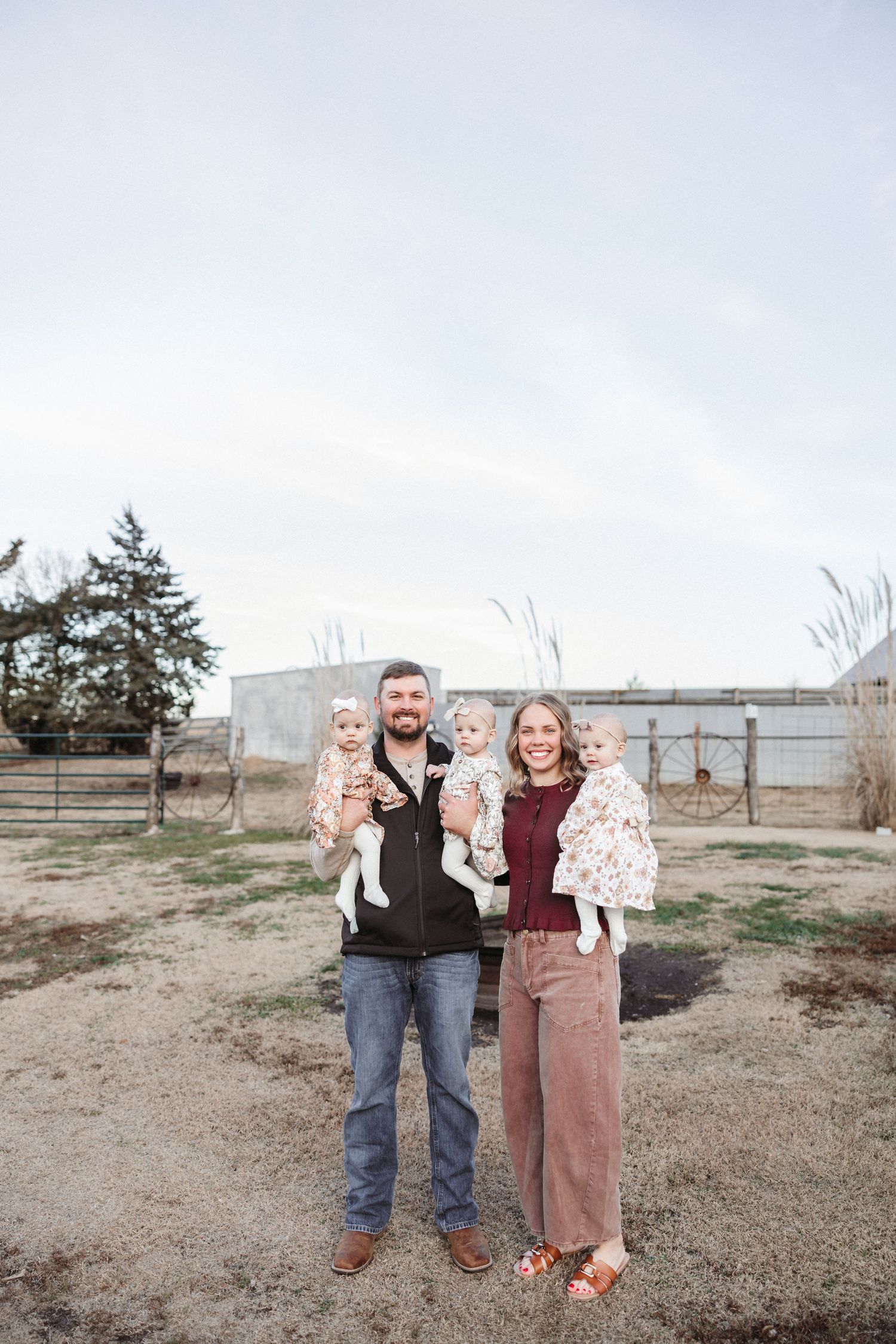 A casual family portrait taken in a rustic outdoor setting.