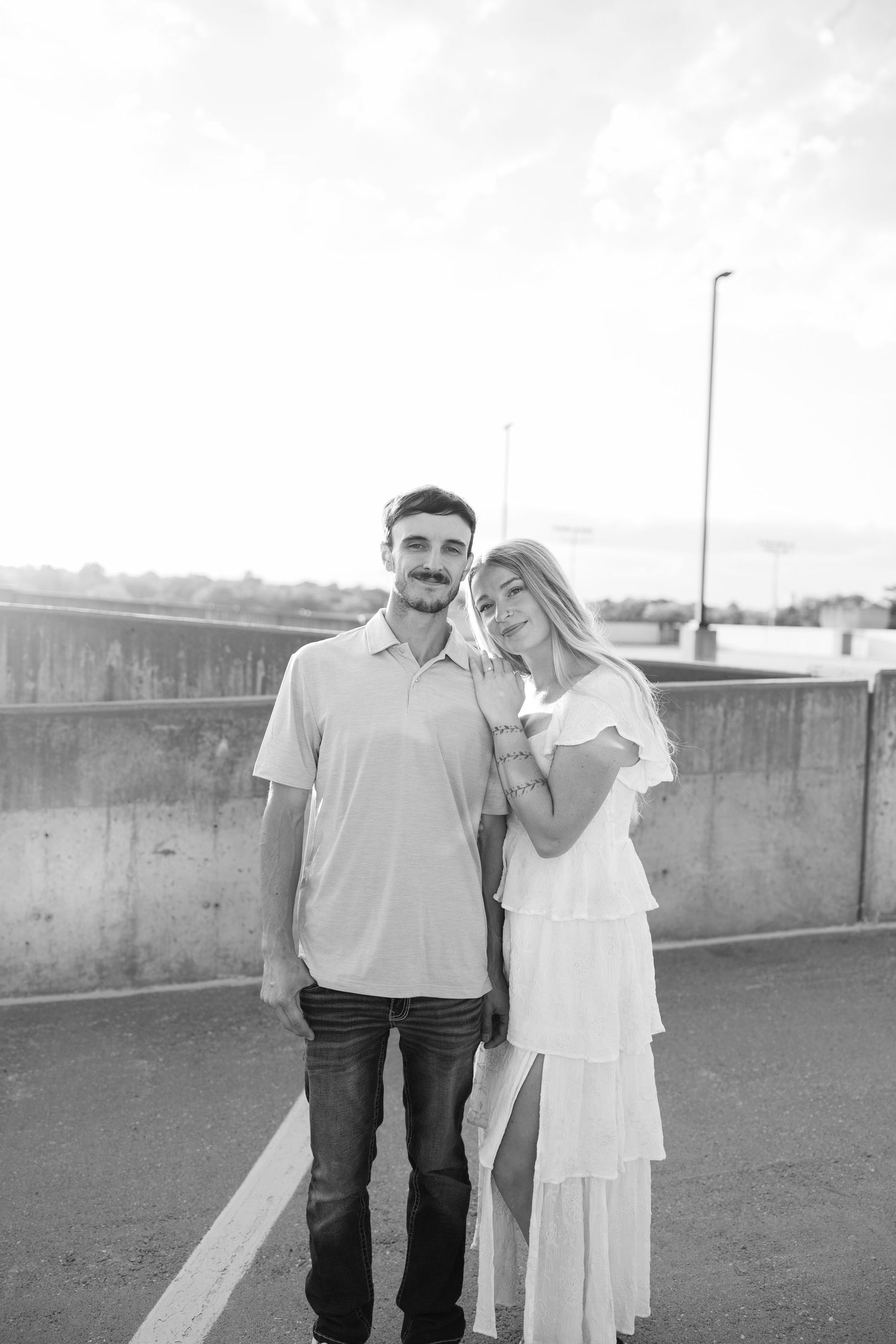 Couple in casual white outfits sharing intimate moments on rooftop setting.
