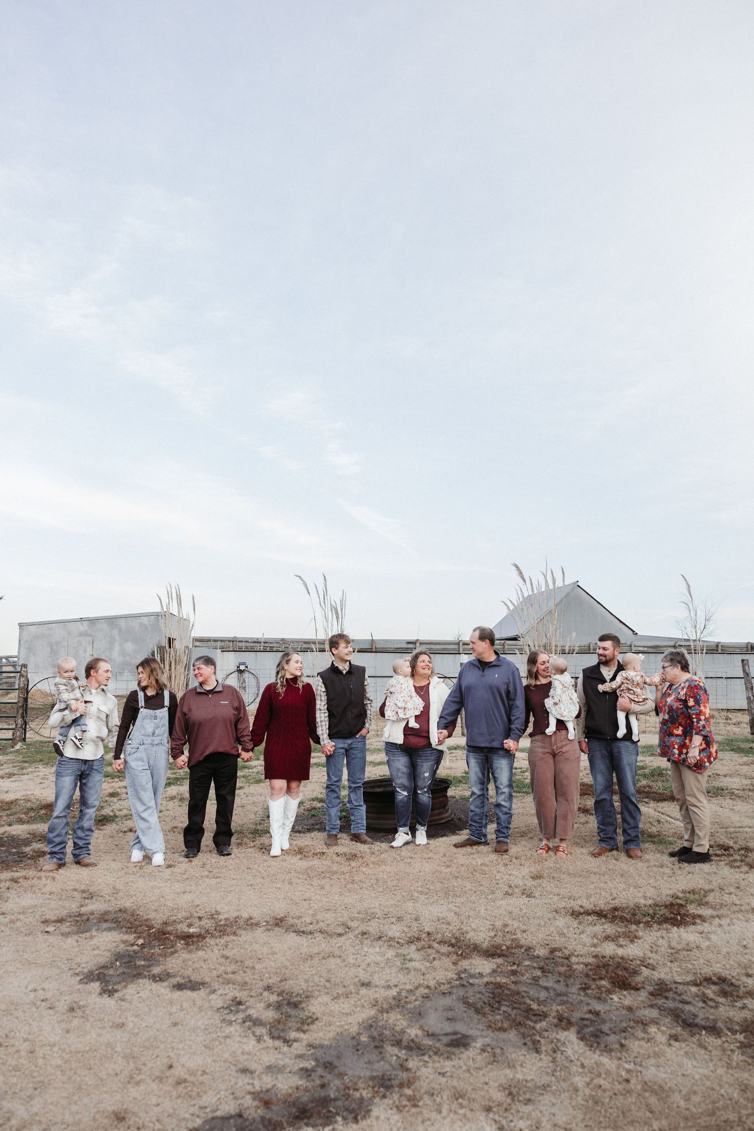 Large extended family group photo lined up outdoors against a rural backdrop.