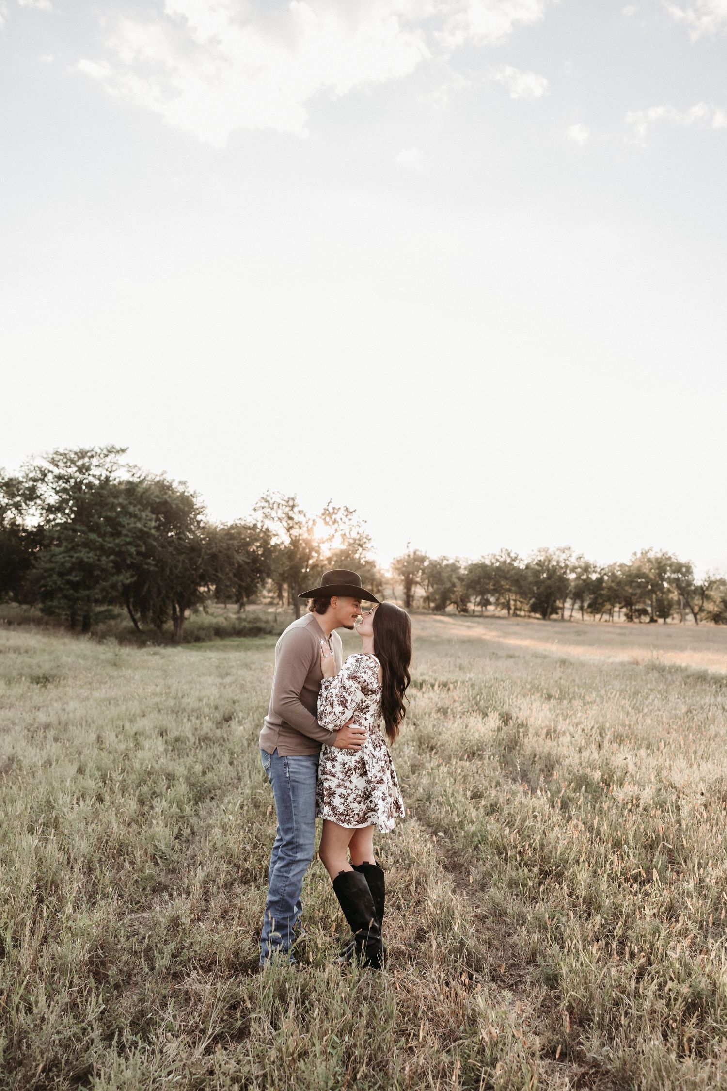 A couple posed so perfect in a peaceful meadow at sunset.