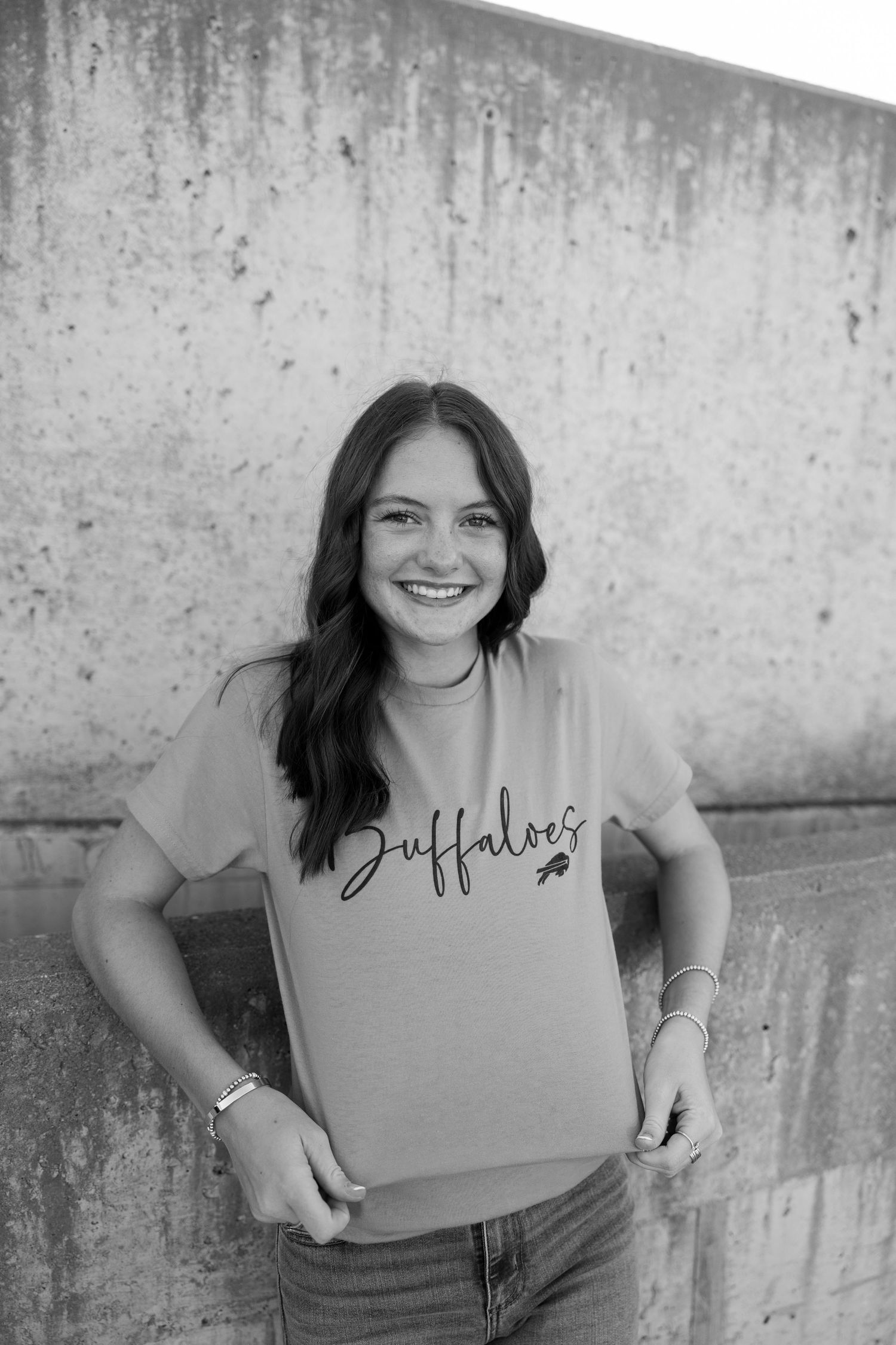 Black and white portrait series against a concrete wall showing casual poses and genuine smiles.