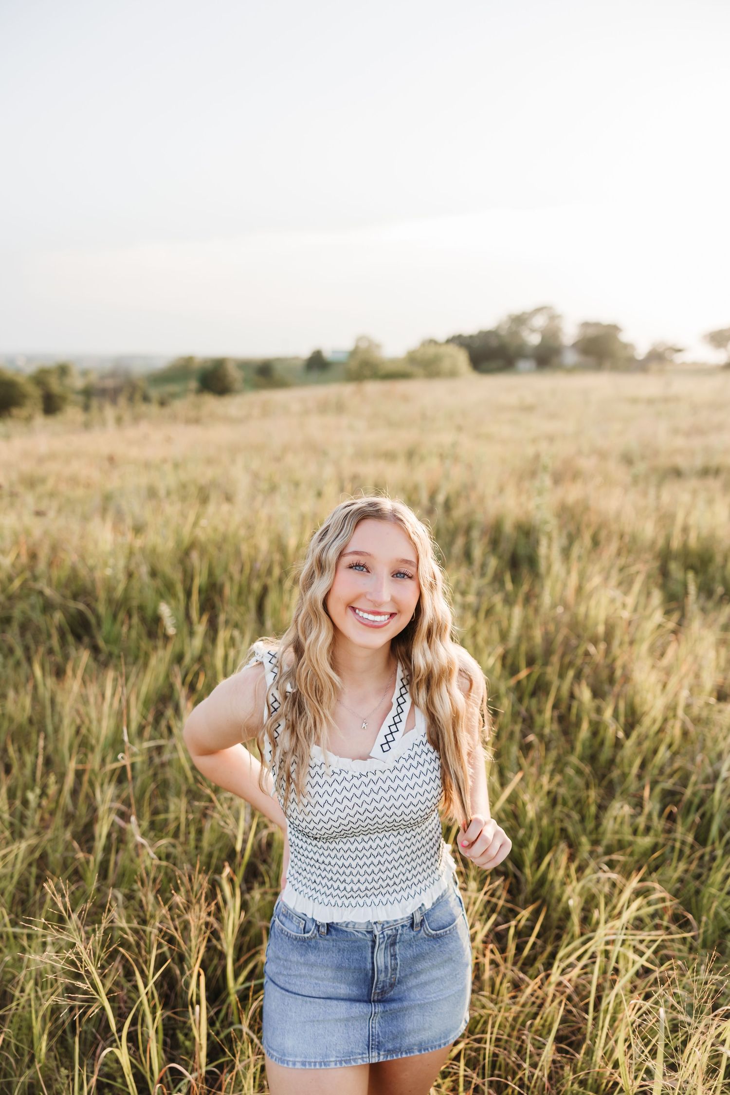 Summer portrait session in tall grass field during golden hour.
