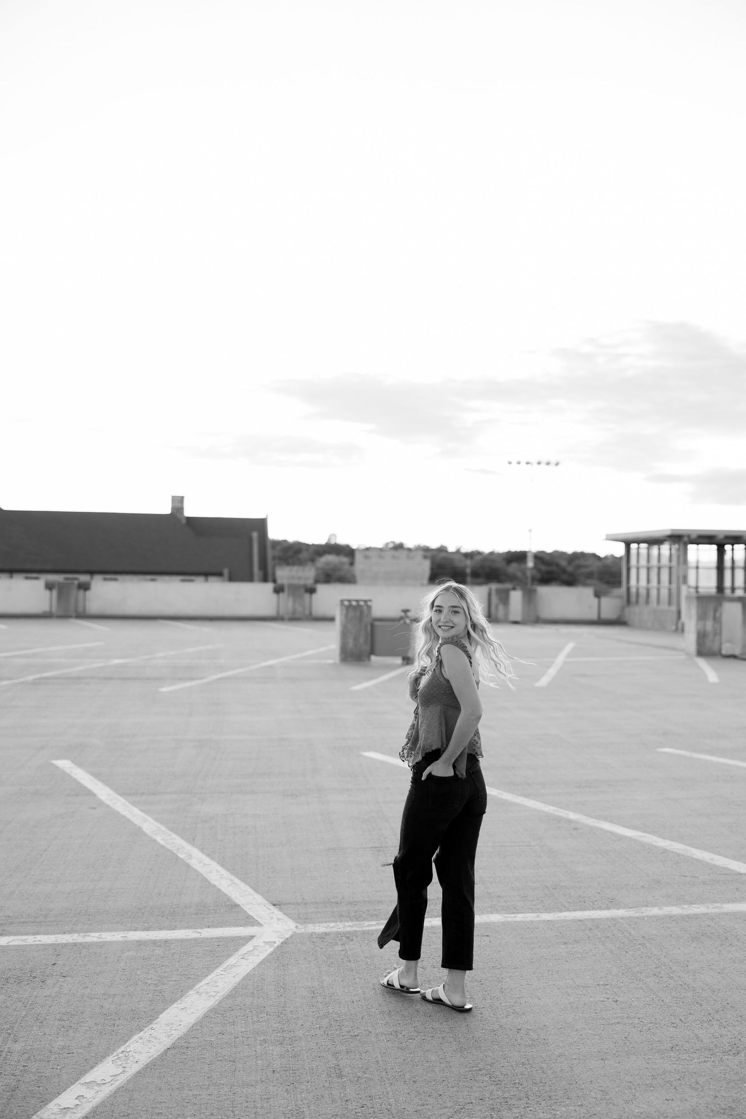 Minimalist black and white photos of people walking across empty parking lot.