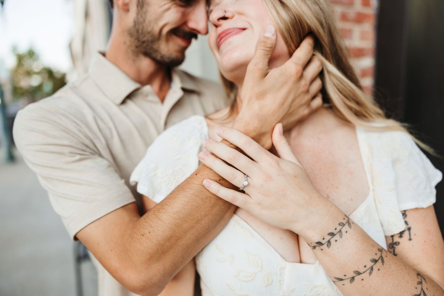 An intimate moment captured between a couple showing affection outdoors.