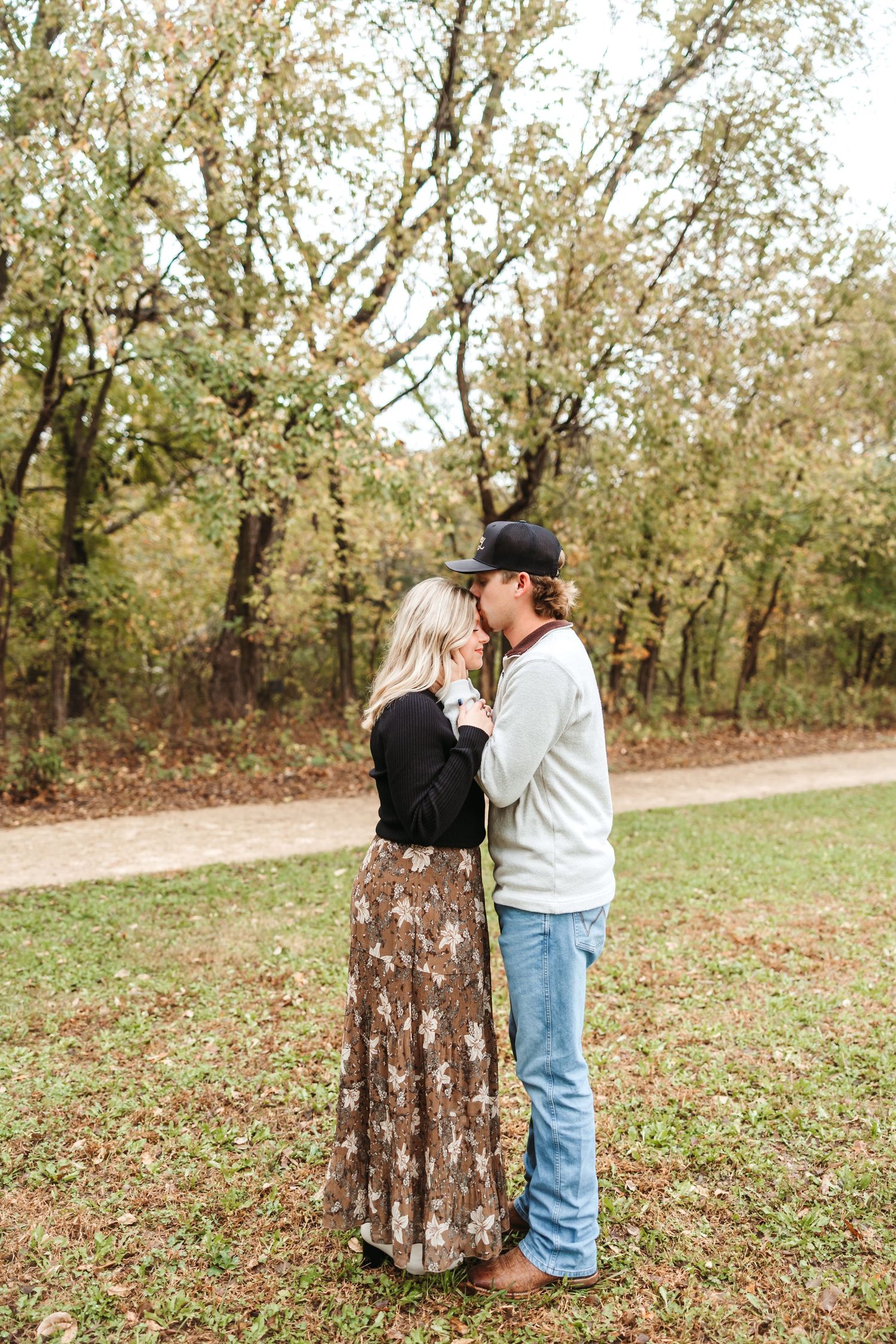 A romantic autumn scene with a couple embracing among blooming trees.