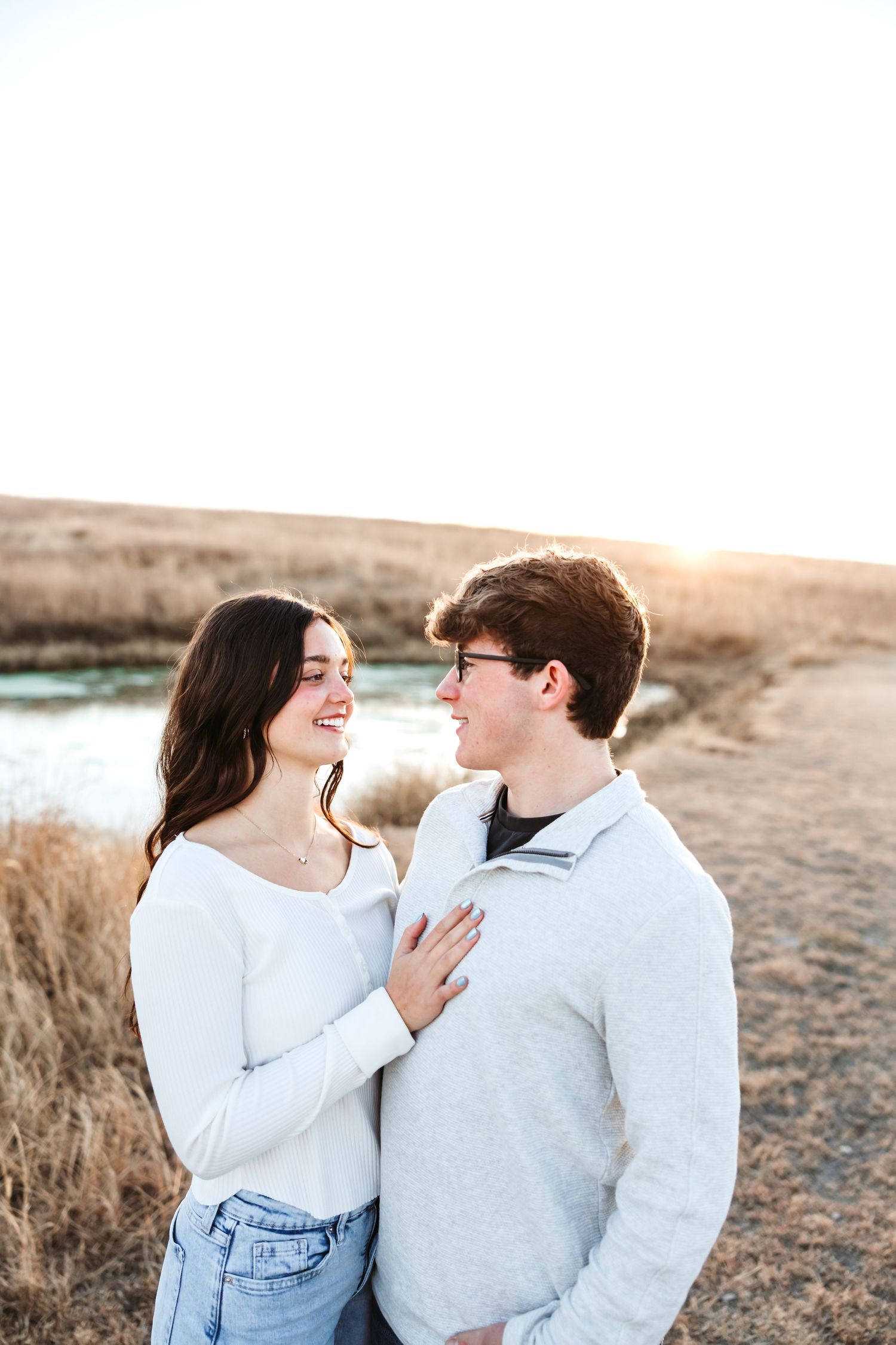A sweet candid moment between a couple against a natural landscape.