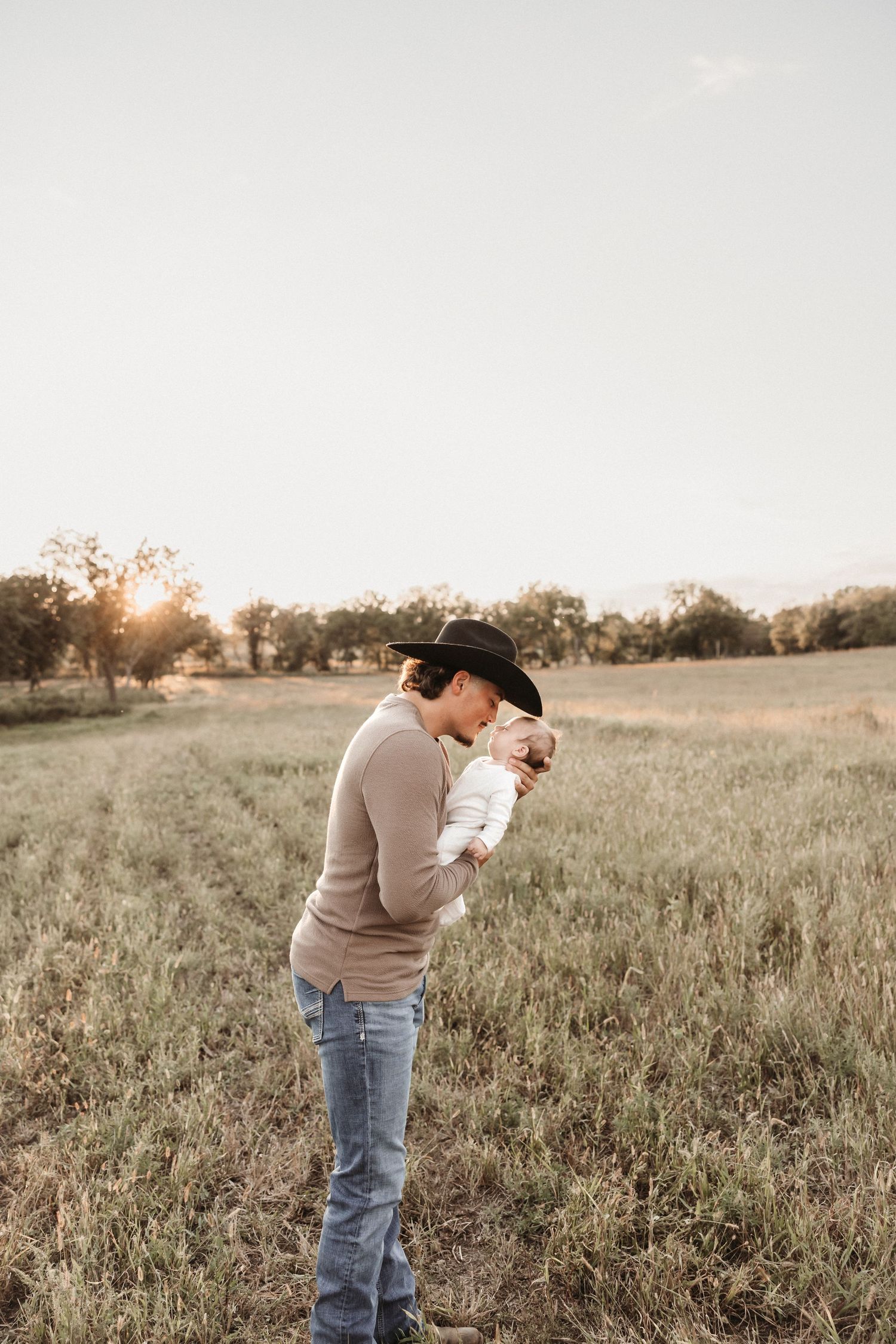 A silhouetted figure bowing in a golden field at sunset.