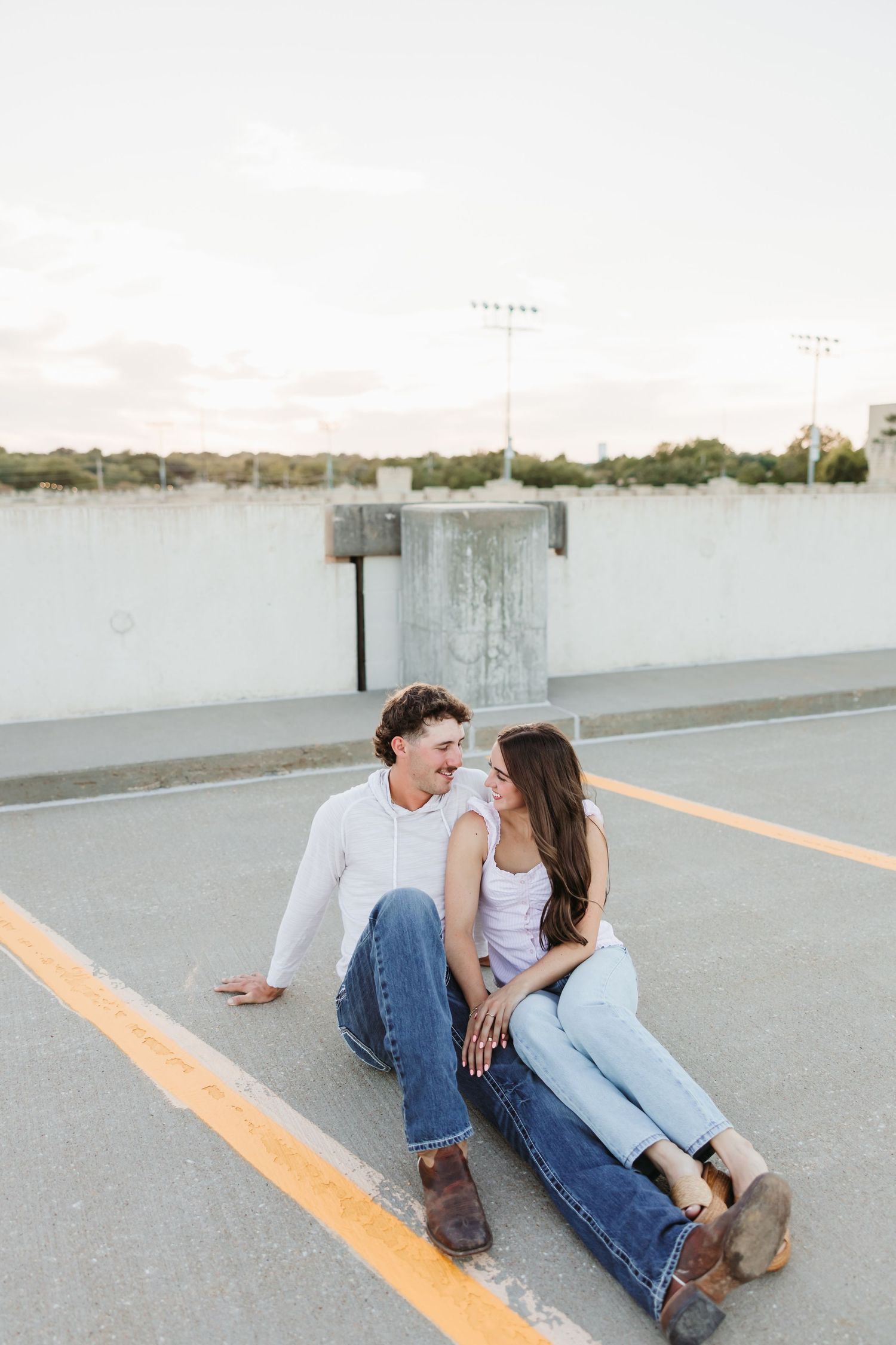 Couple sitting and laughing together in parking garage.