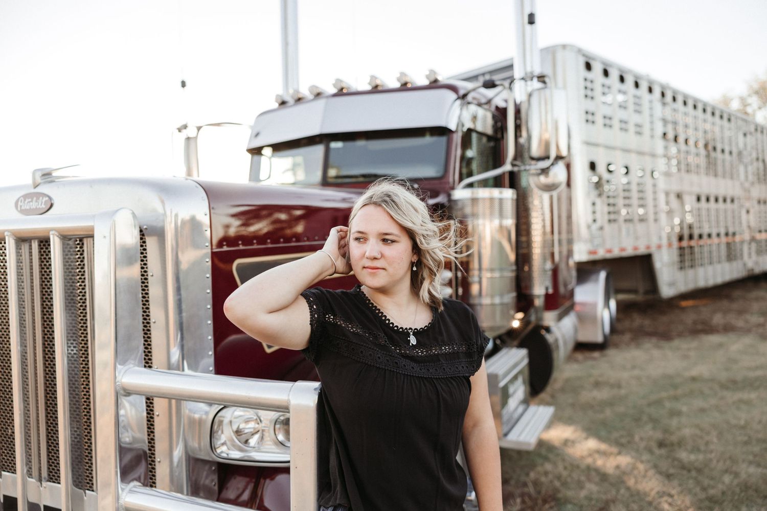Woman in black top in front of her dads semi.