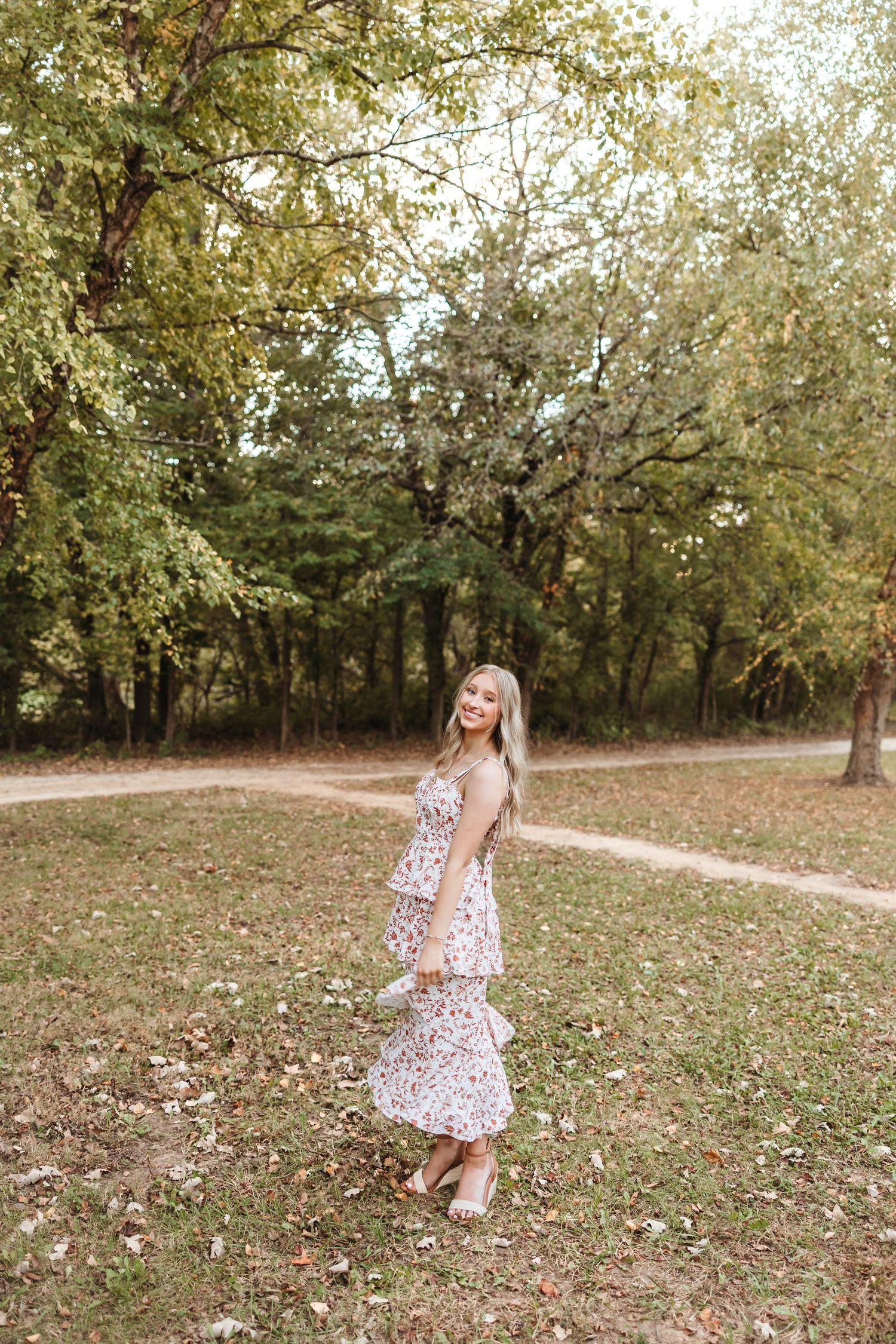 Autumn photoshoot with fallen leaves in a park setting.