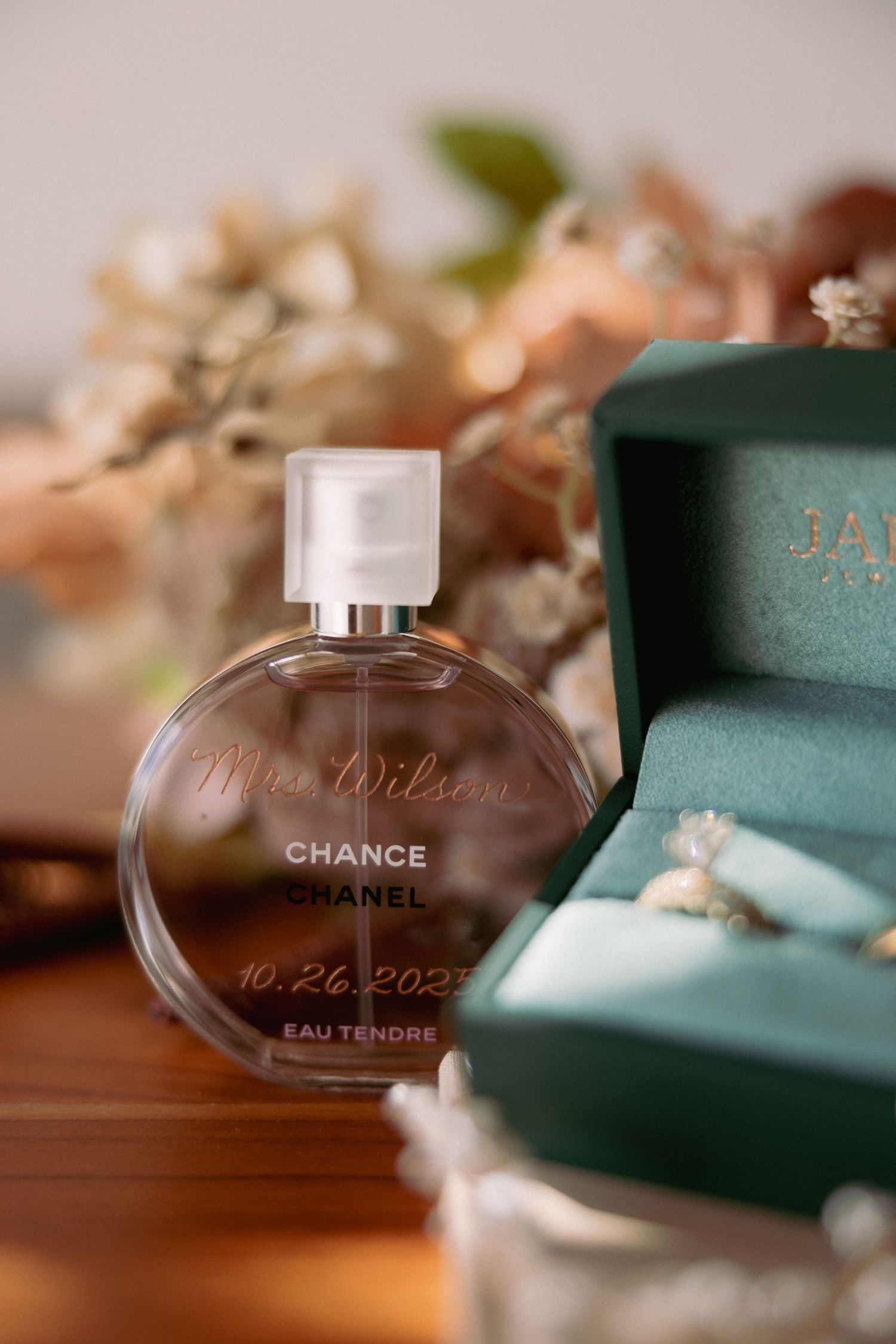 Chanel Chance Eau Tendre perfume bottle engraved with Mrs. Wilson and wedding date beside a teal ring box.