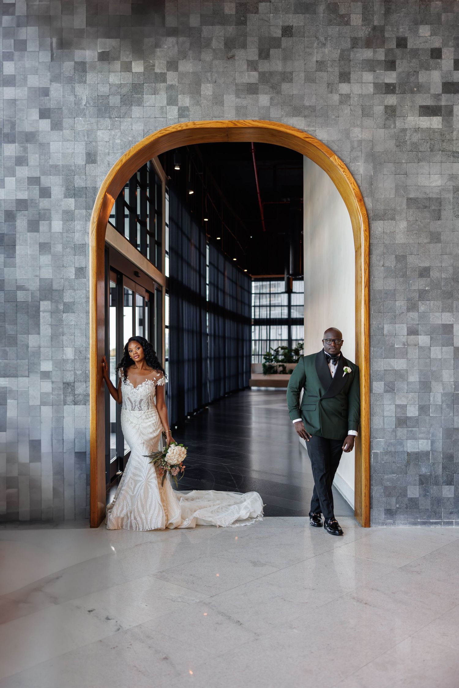 High end picture of Bride and groom pose in a golden arched doorway at a wedding venue in Cancun.