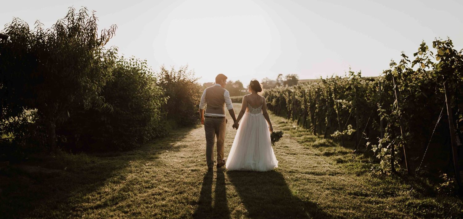 Brautpaar läuft bei Hochzeitsshooting in den Weinbergen Esslingen, beim Sonnenuntergang.