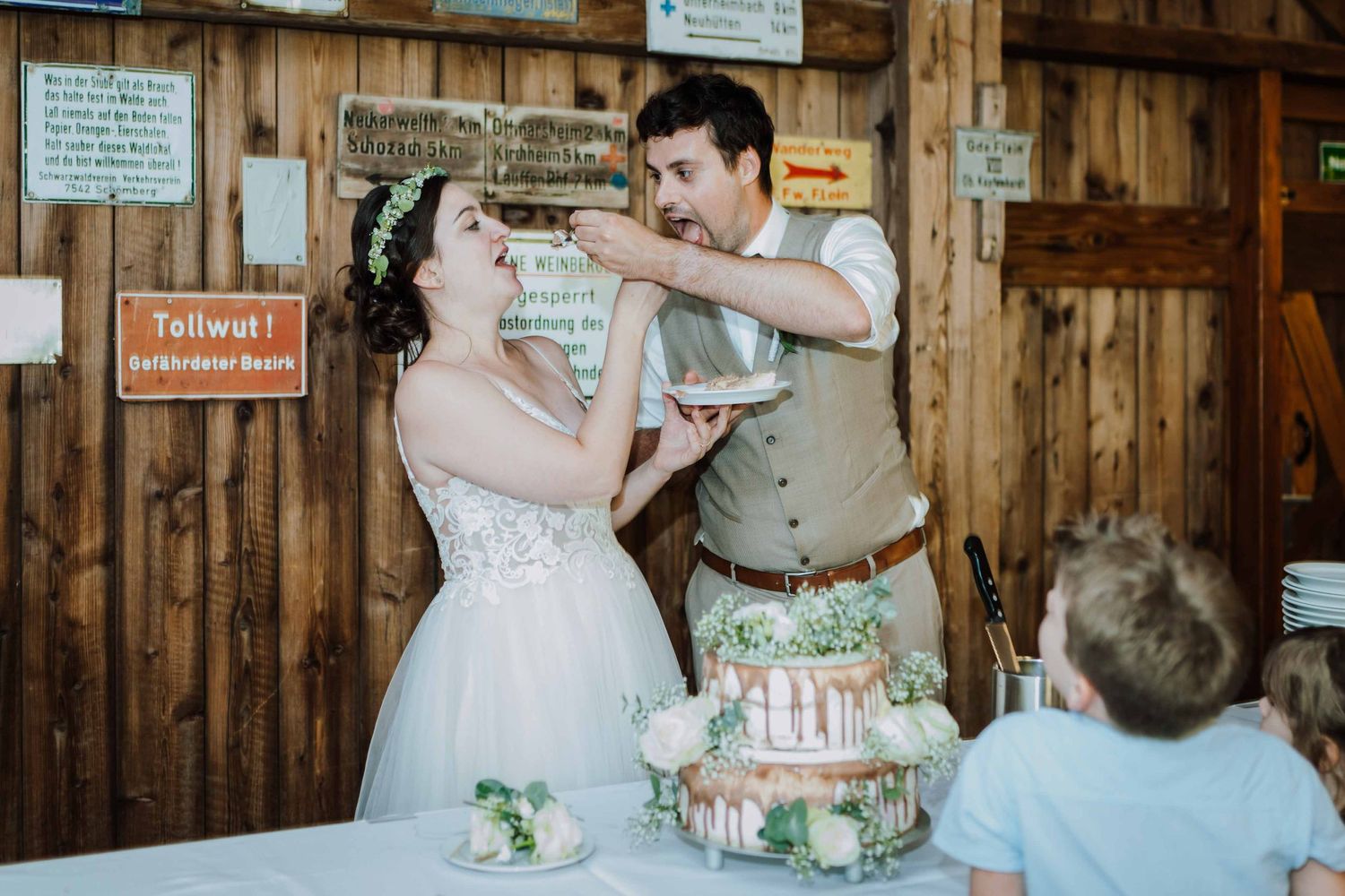 Fotografin fotografiert Hochzeitstorte  bei einer Scheunenhochzeit in Esslingen, im Bohostil. Brautpaar füttert sich gegenseitig