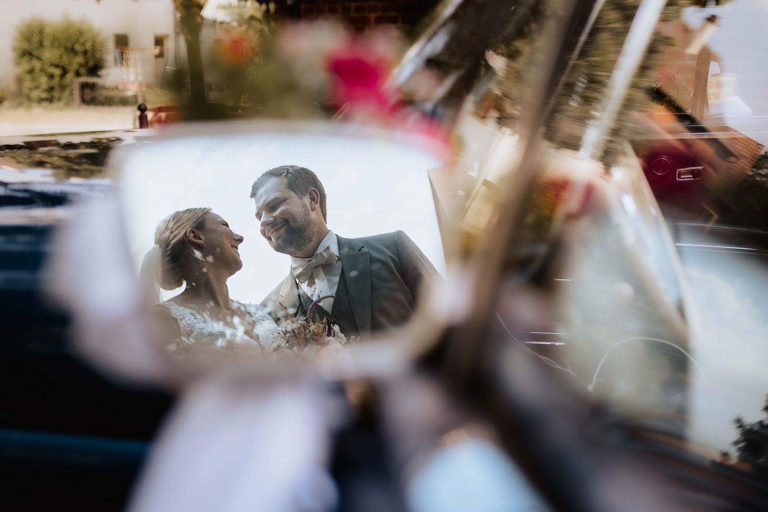Brautpaar in Klosterhof in Denkendorf mit Hochzeitsauto im Rückspiegel