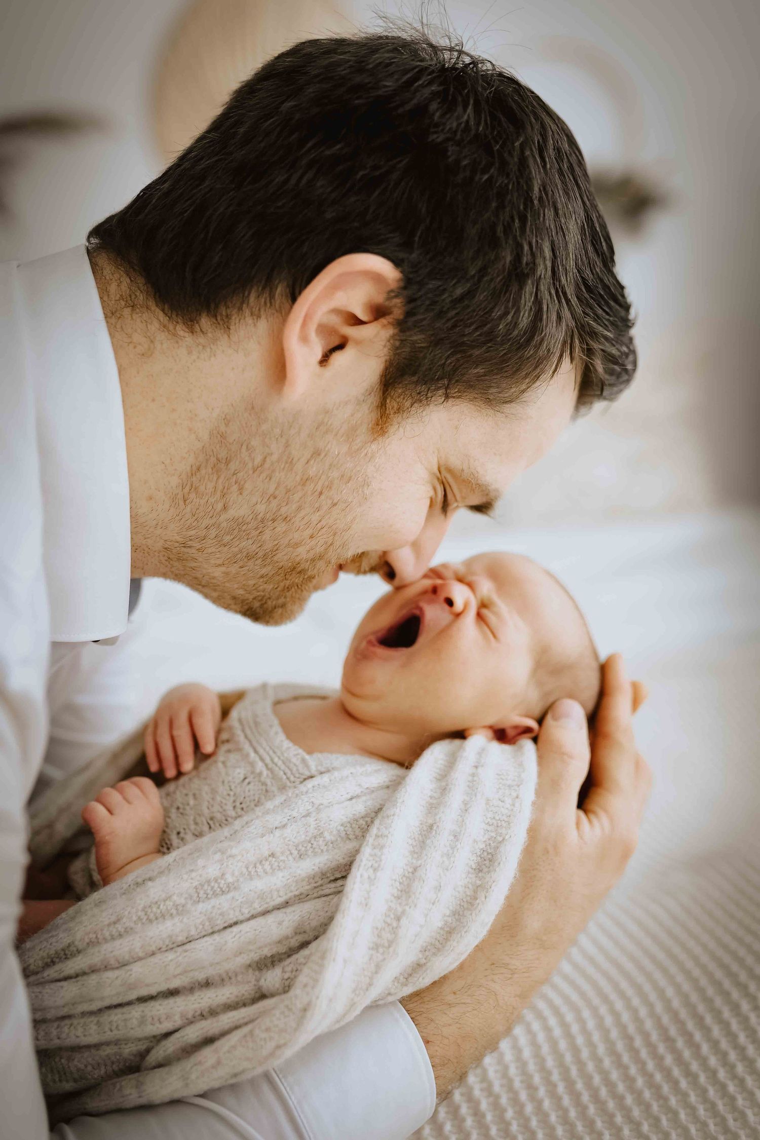 Baby schläft im Arm von Papa, natürlich im Studio fotografiert