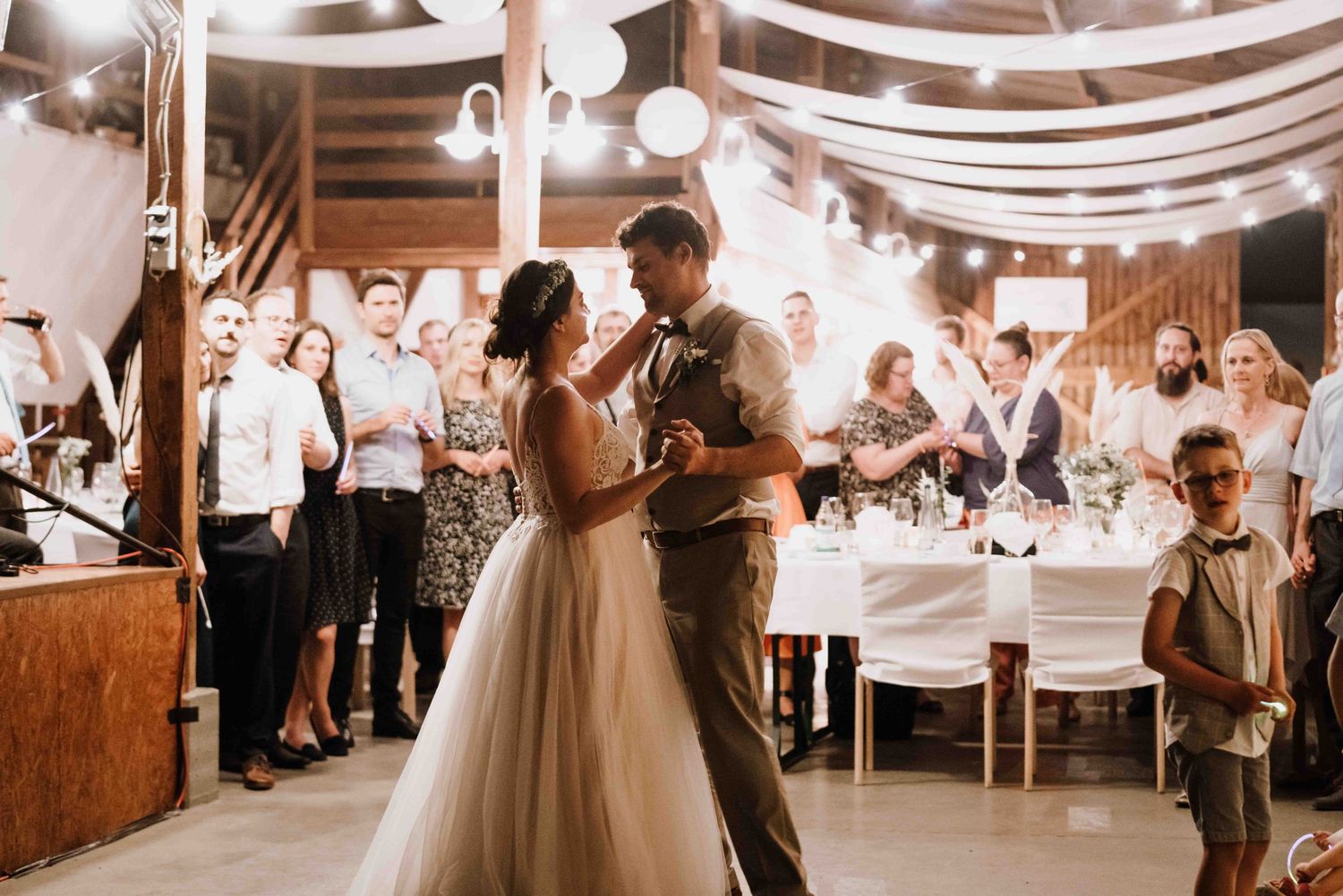 Fotografin fotografiert Hochzeitstanz bei einer Scheunenhochzeit in Esslingen, im Bohostil. Brautpaar tanzt