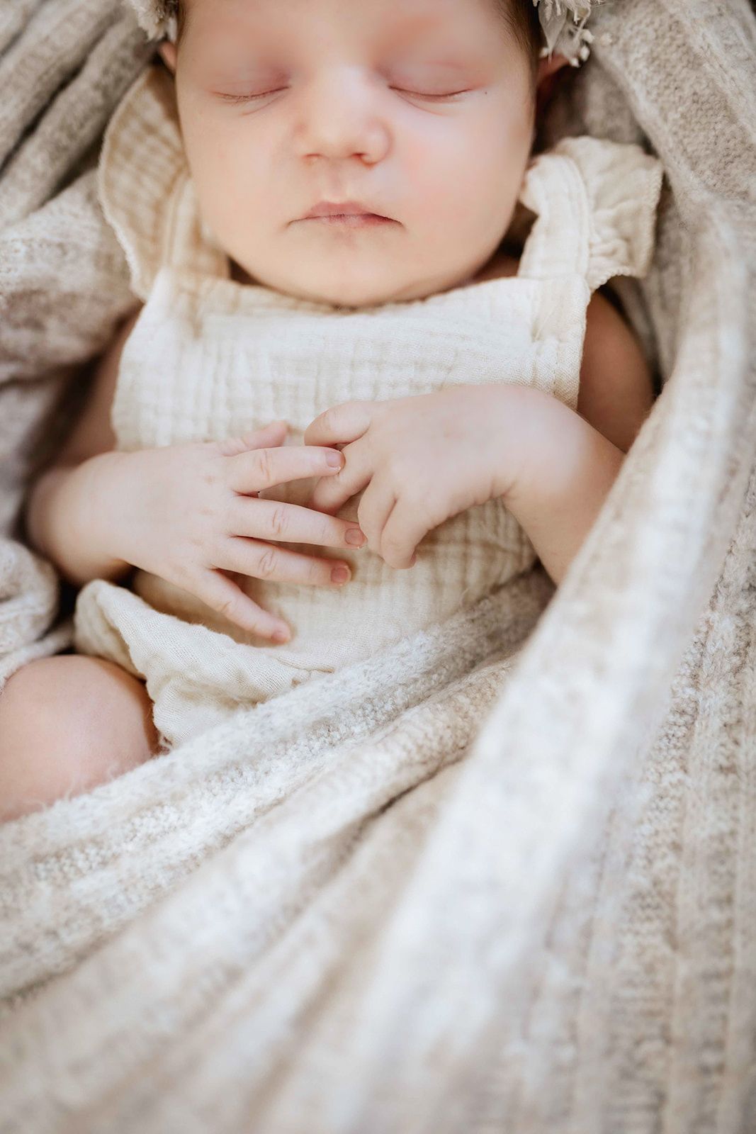 Baby schläft im Korb eingewickelt in einen wrap, natürlich im Studio fotografiert