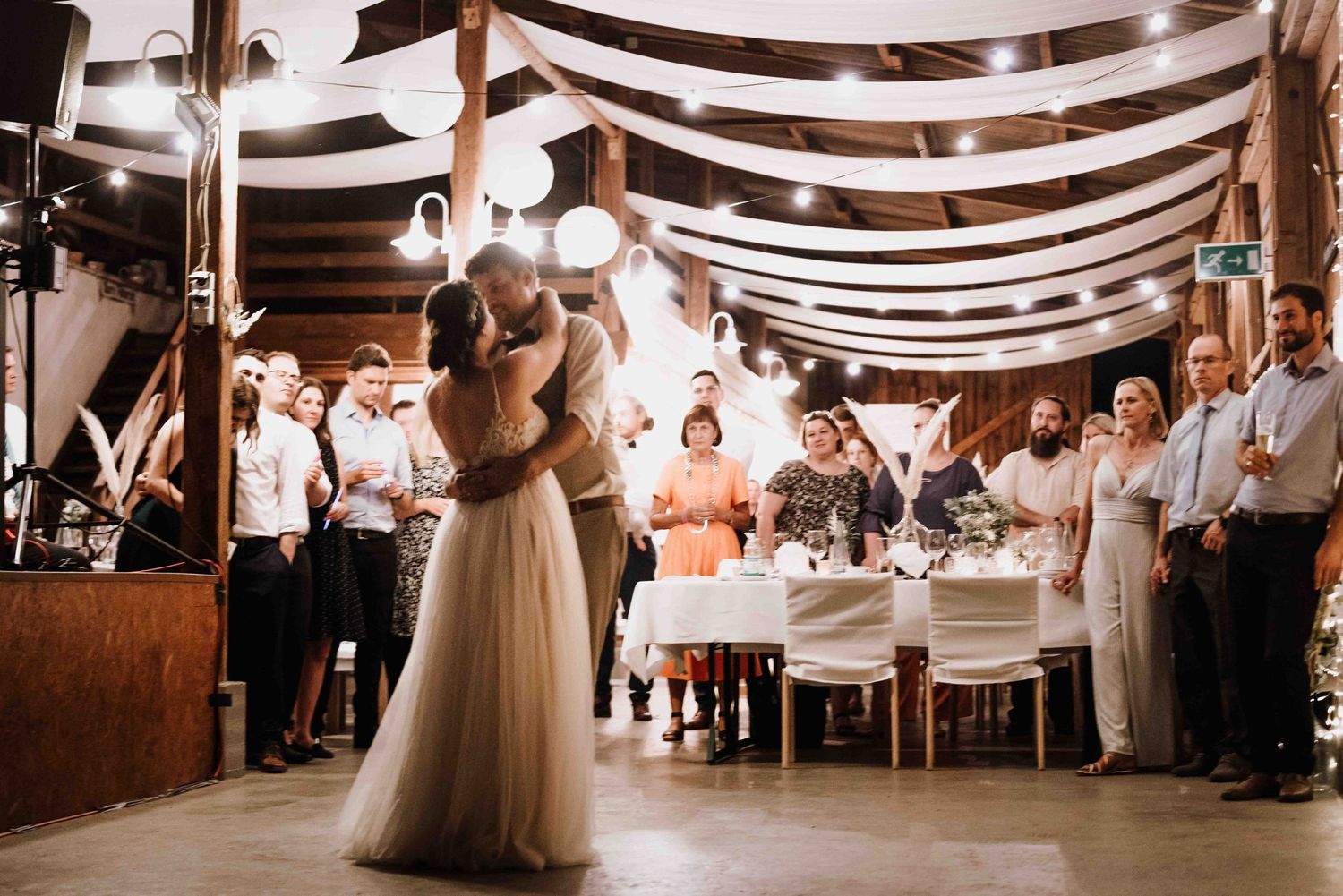 Fotografin fotografiert Hochzeitstanz bei einer Scheunenhochzeit in Esslingen, im Bohostil. Brautpaar küsst sich