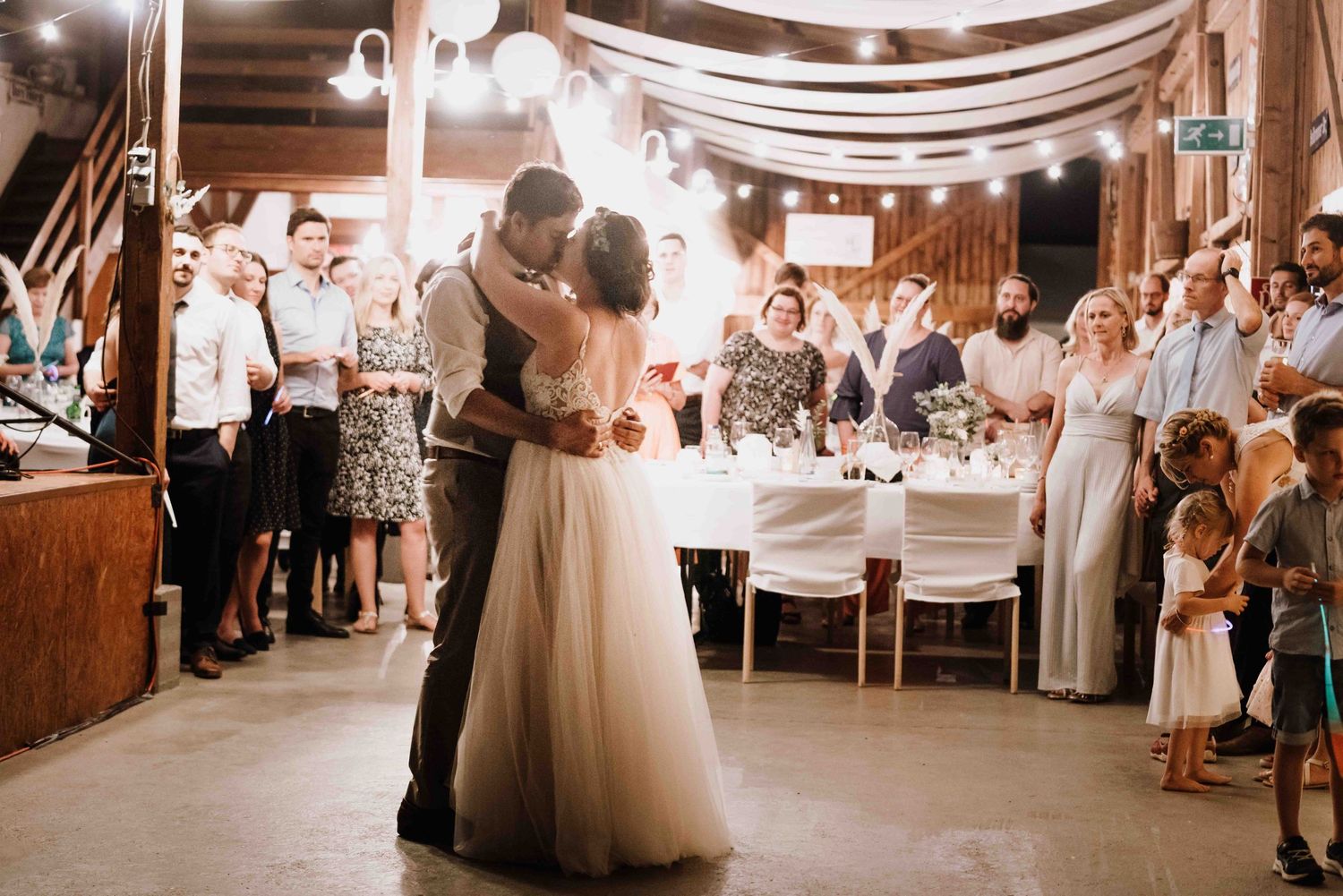 Fotografin fotografiert Hochzeitstanz bei einer Scheunenhochzeit in Esslinge, im Bohostil. Brautpaar küsst sich
