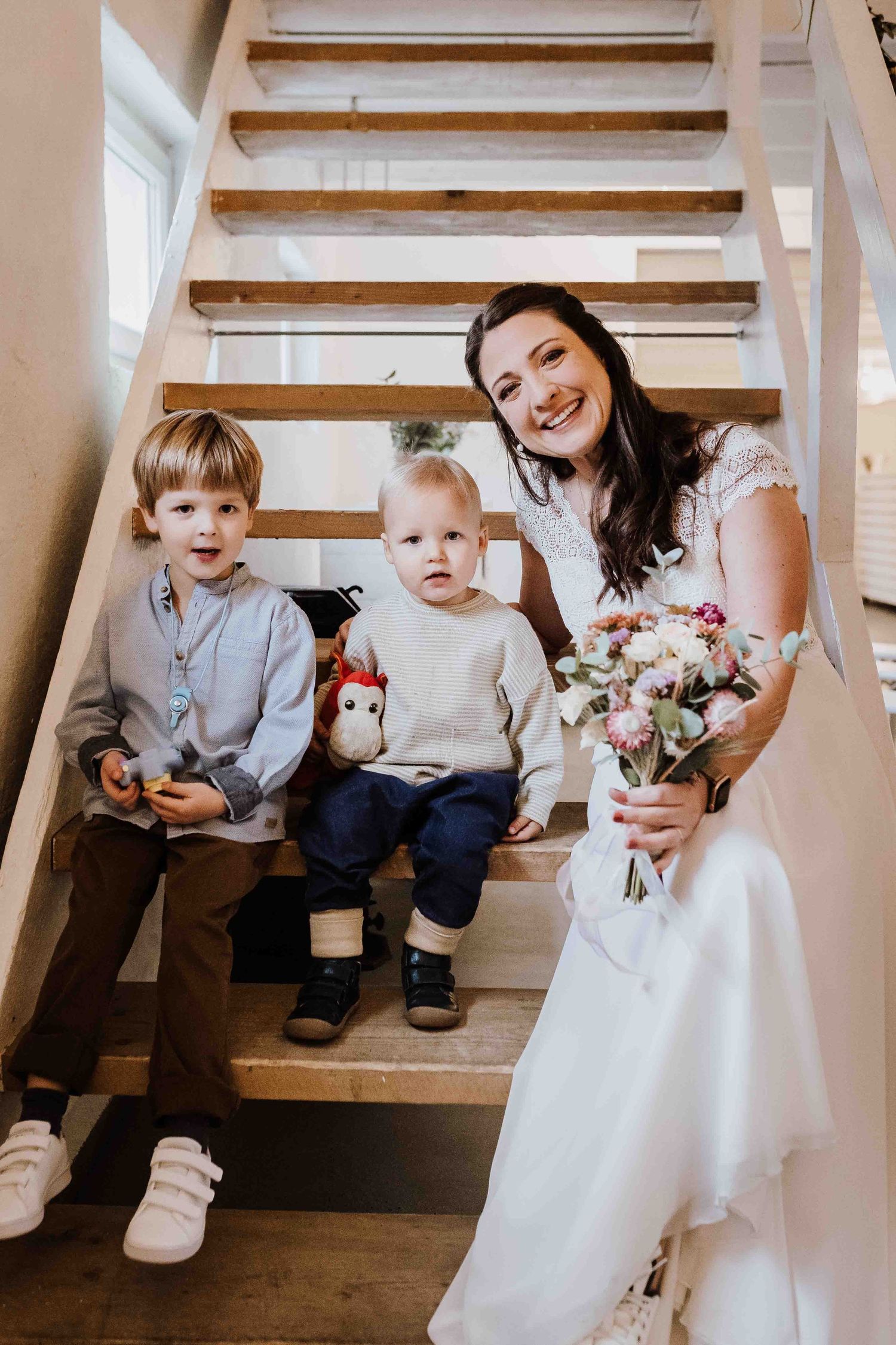 Braut sitzt mit 2 Kindern auf Treppe, emotionale und romantische Hochzeit in der Remise Stuttgart