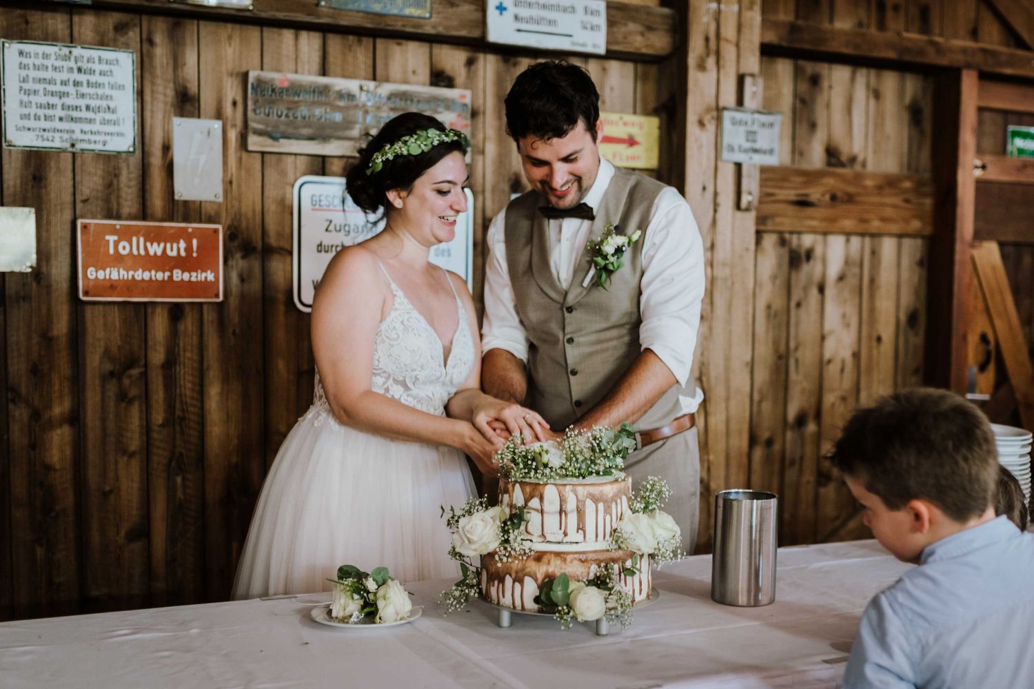 Hochzeittorte bei einer Scheunenhochzeit in Esslingen im Bohostil. Brautpaar schneidet Hochzeitstorte.