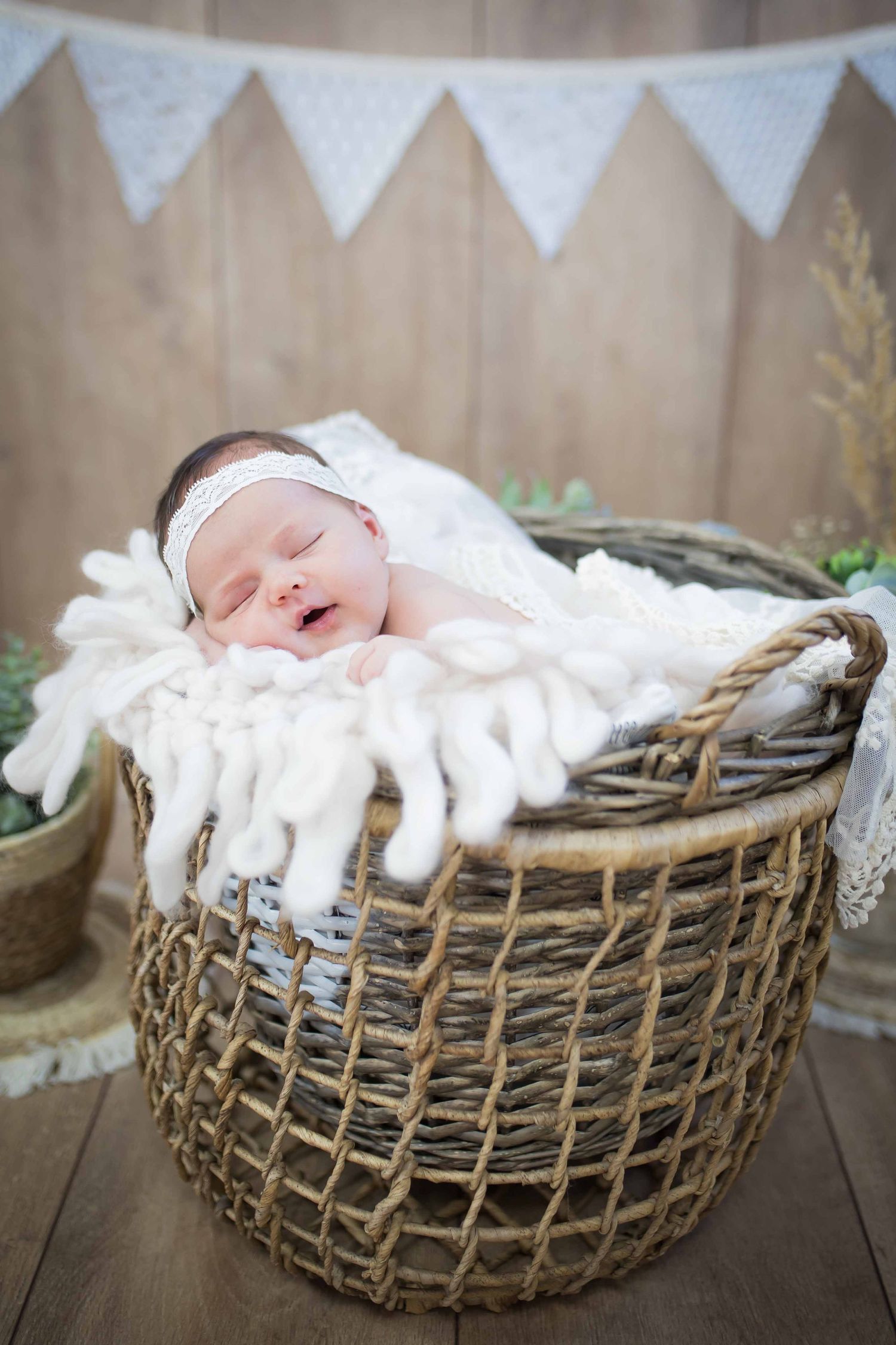 Baby liegt im Korb, zugedeckt mit Decke und schläft, fotografiert im Tageslichtstudio in Denkendorf