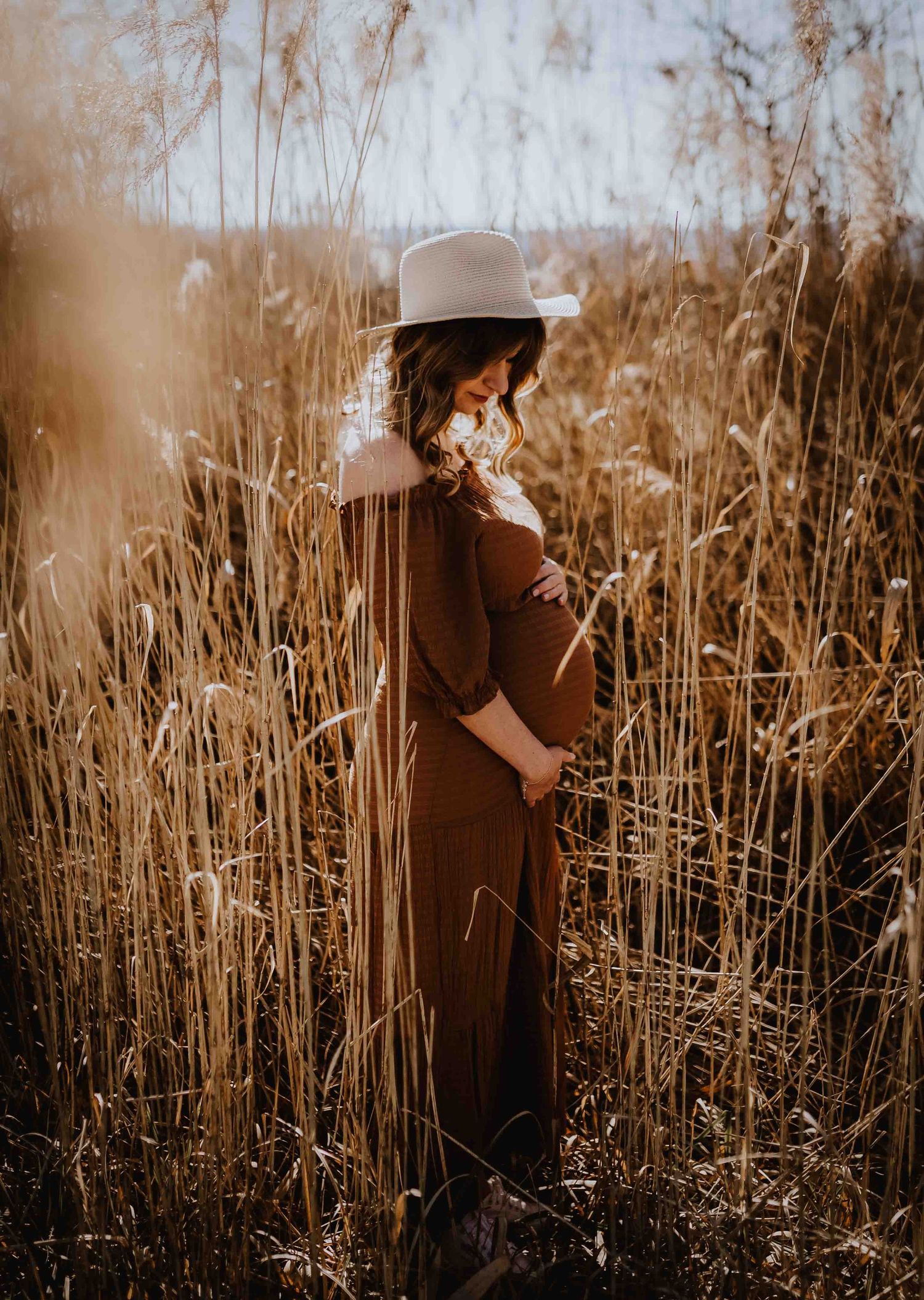 Babybauchfotos im Feld fotografiert mit bohokleid und Hut