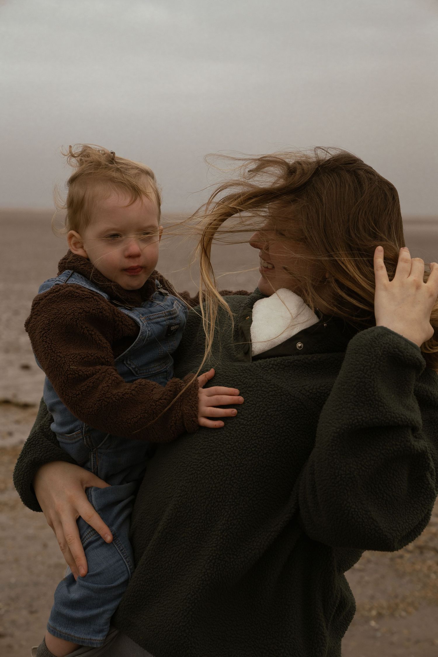 photographer behind the lens carrying new born baby holding toddler