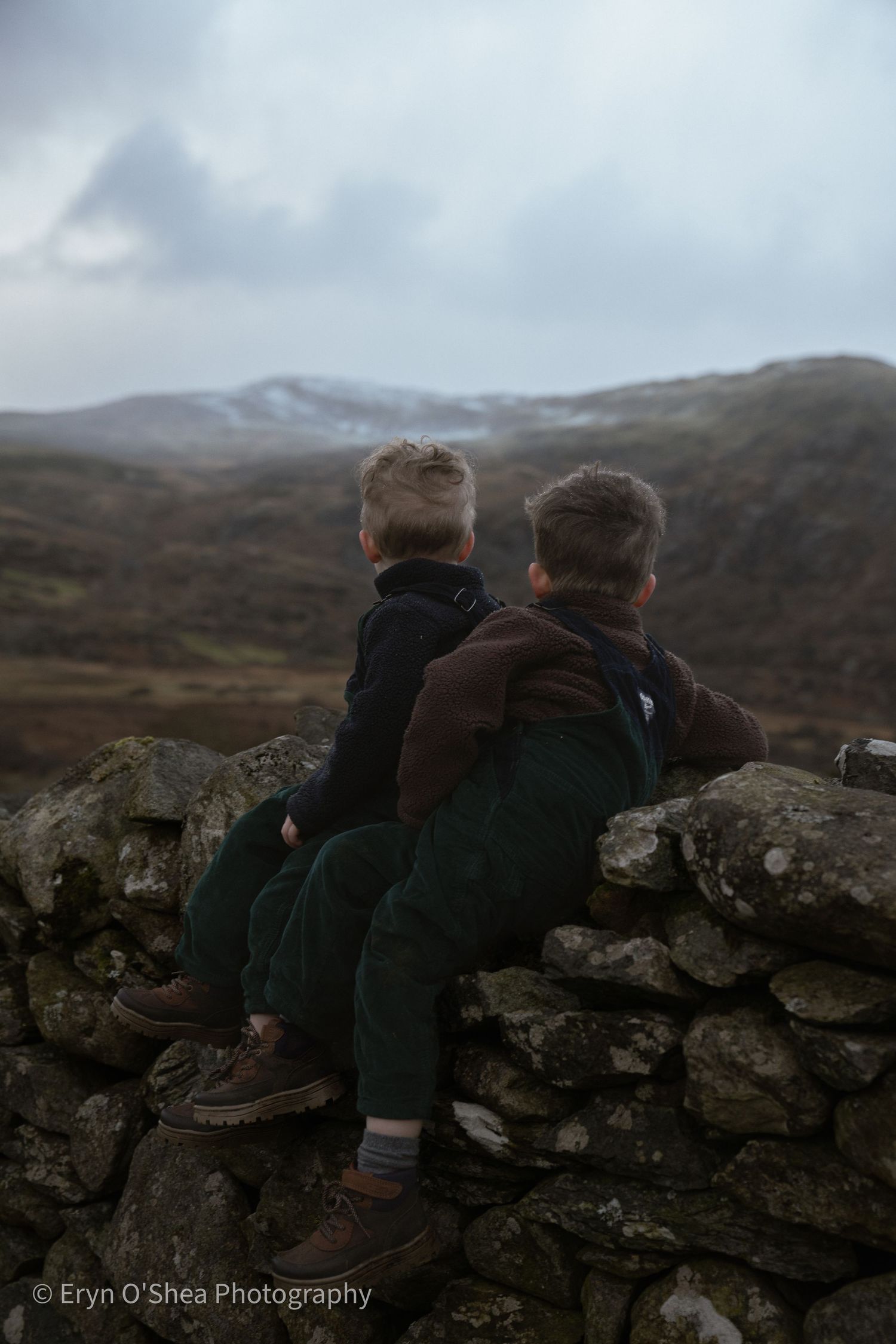 Two children looking out at mountains during outdoor adventure