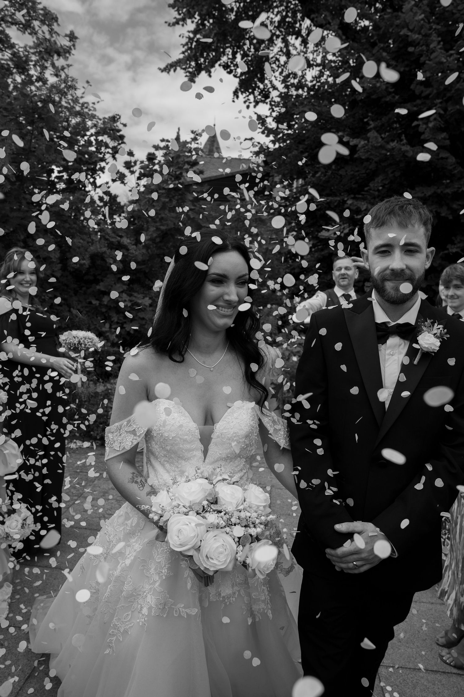 Bride and groom walking through confetti toss during wedding celebration