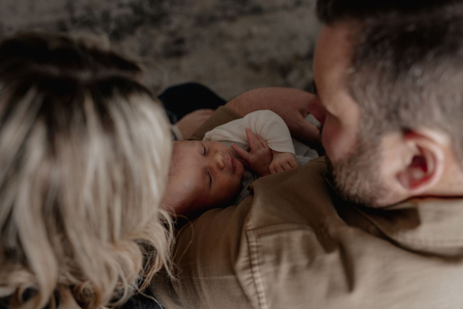 New parents with newborn baby captured in relaxed in-home session
