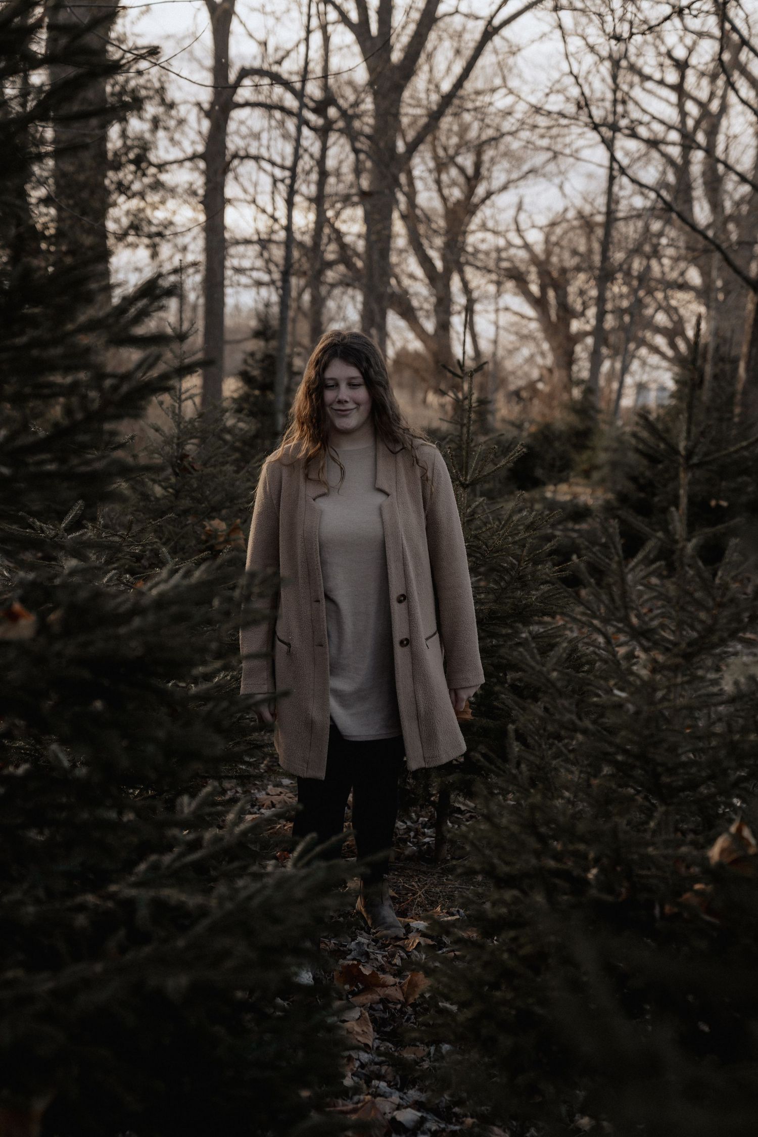 girl walking through tree farm